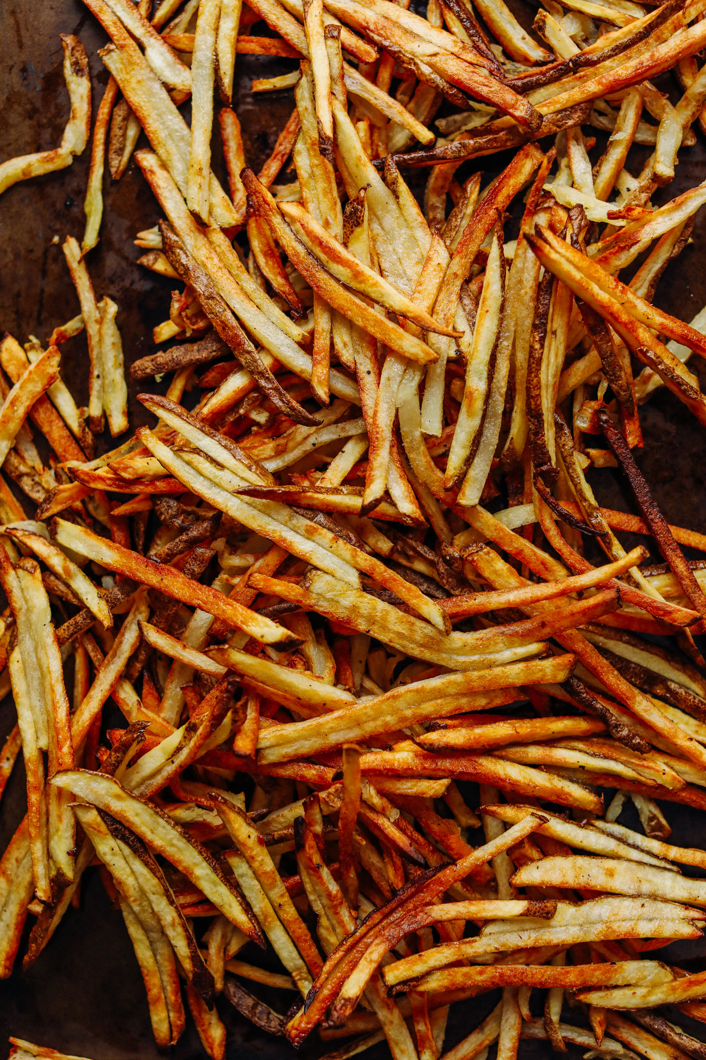 Baking sheet filled with perfectly crispy homemade fries for Vegan Poutine