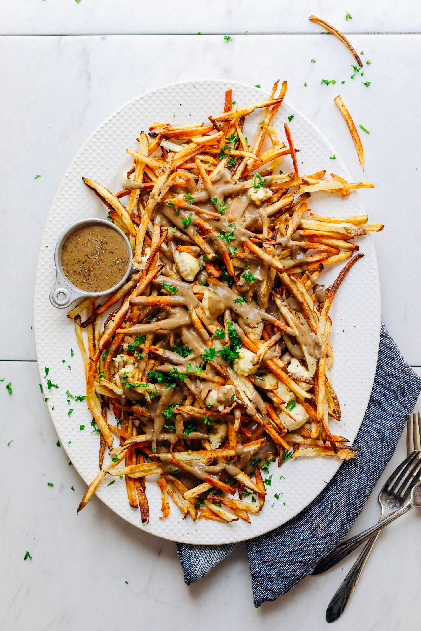 Large white ceramic platter with our amazing Vegan Poutine recipe