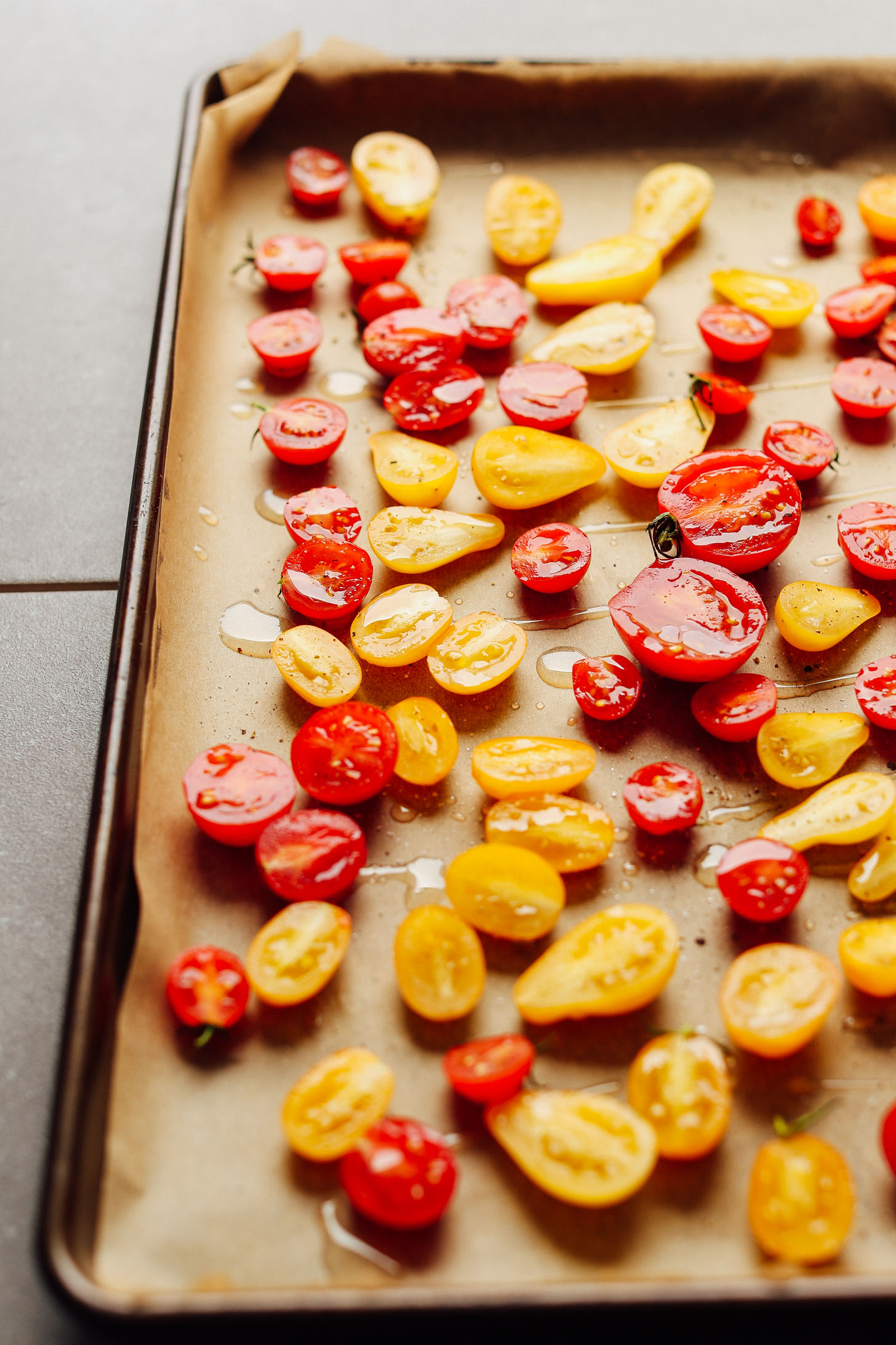 Baking sheet filled with red and yellow Slow Roasted Cherry Tomatoes for adding to salads and more