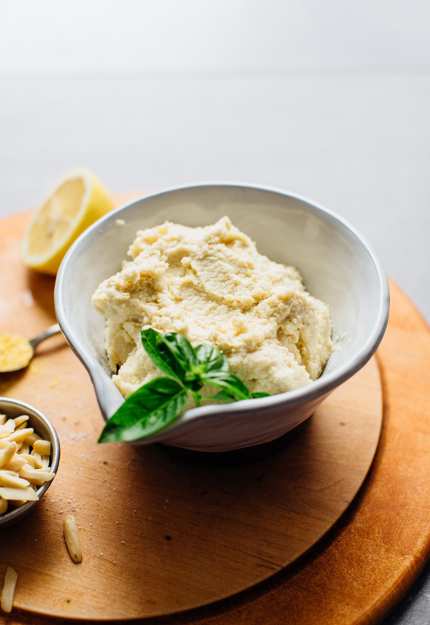 Close up shot of a bowl of Vegan Ricotta Cheese garnished with fresh basil leaves