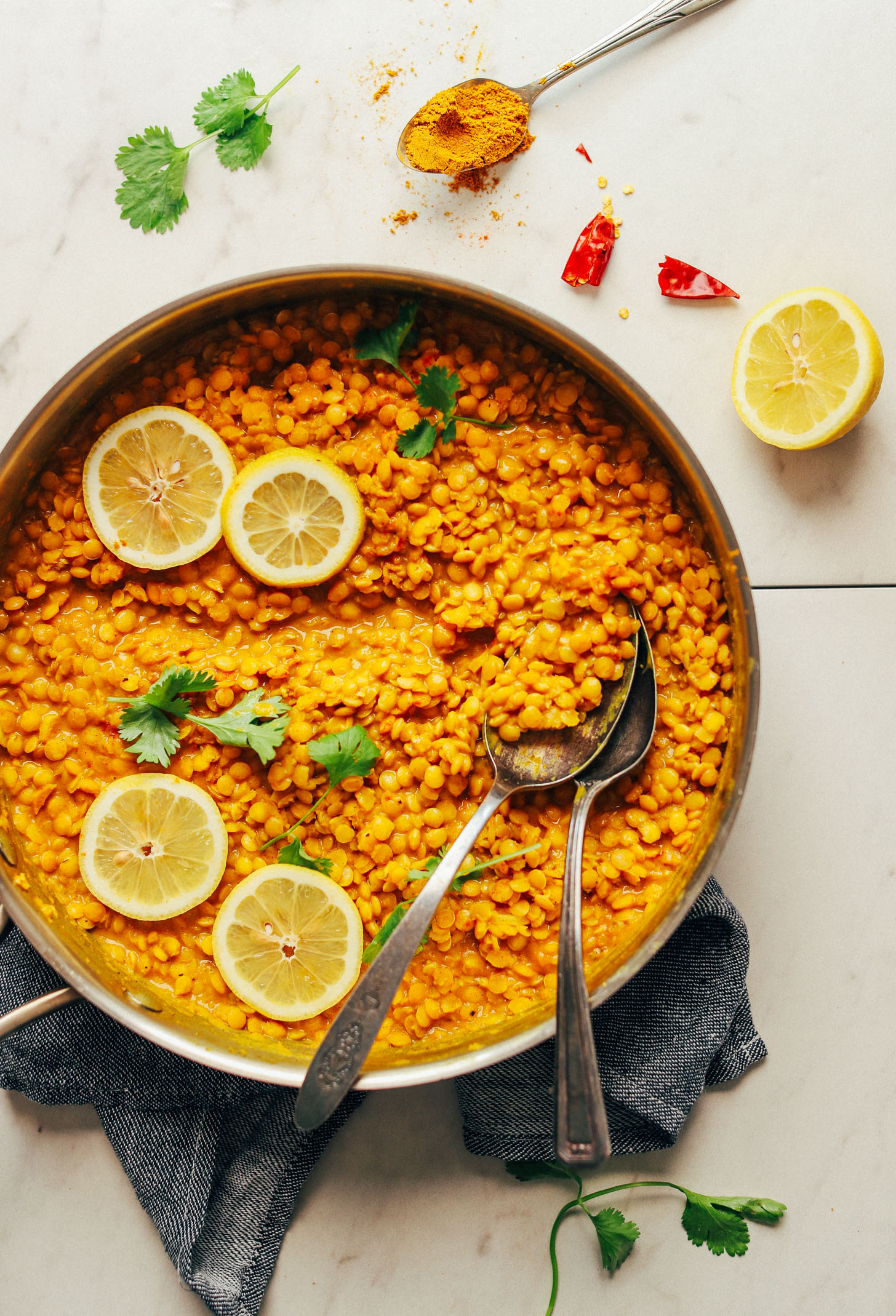 Large pan of vegan gluten-free Coconut Curried Golden Lentils with fresh lemon slices