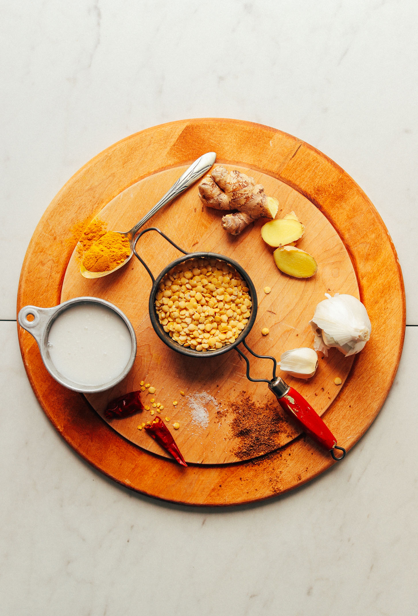 Wood serving platter with ingredients for making vegan Coconut Curried Golden Lentils