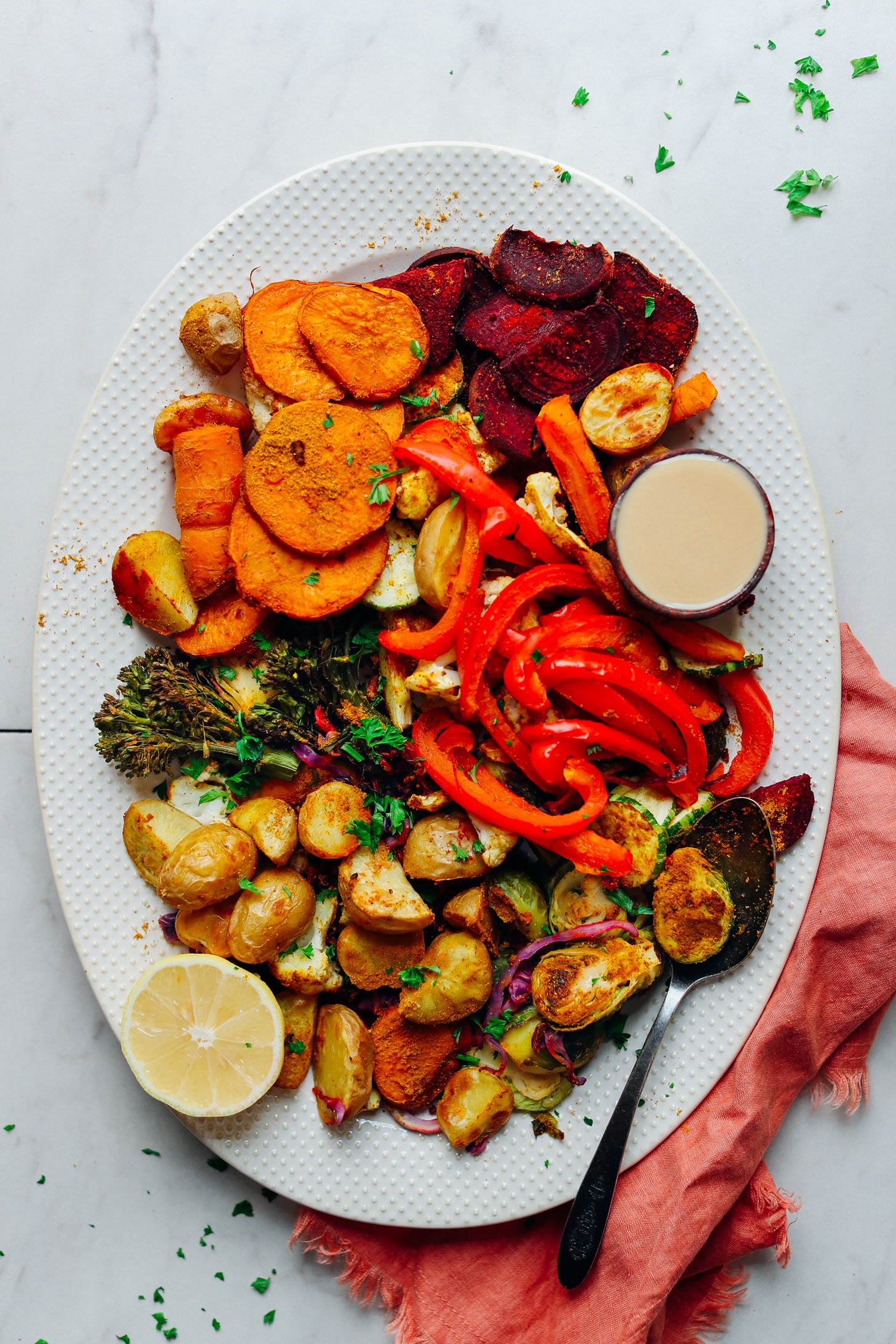 Serving platter filled with colorful Oil-Free Roasted Vegetables with lemon and tahini for serving