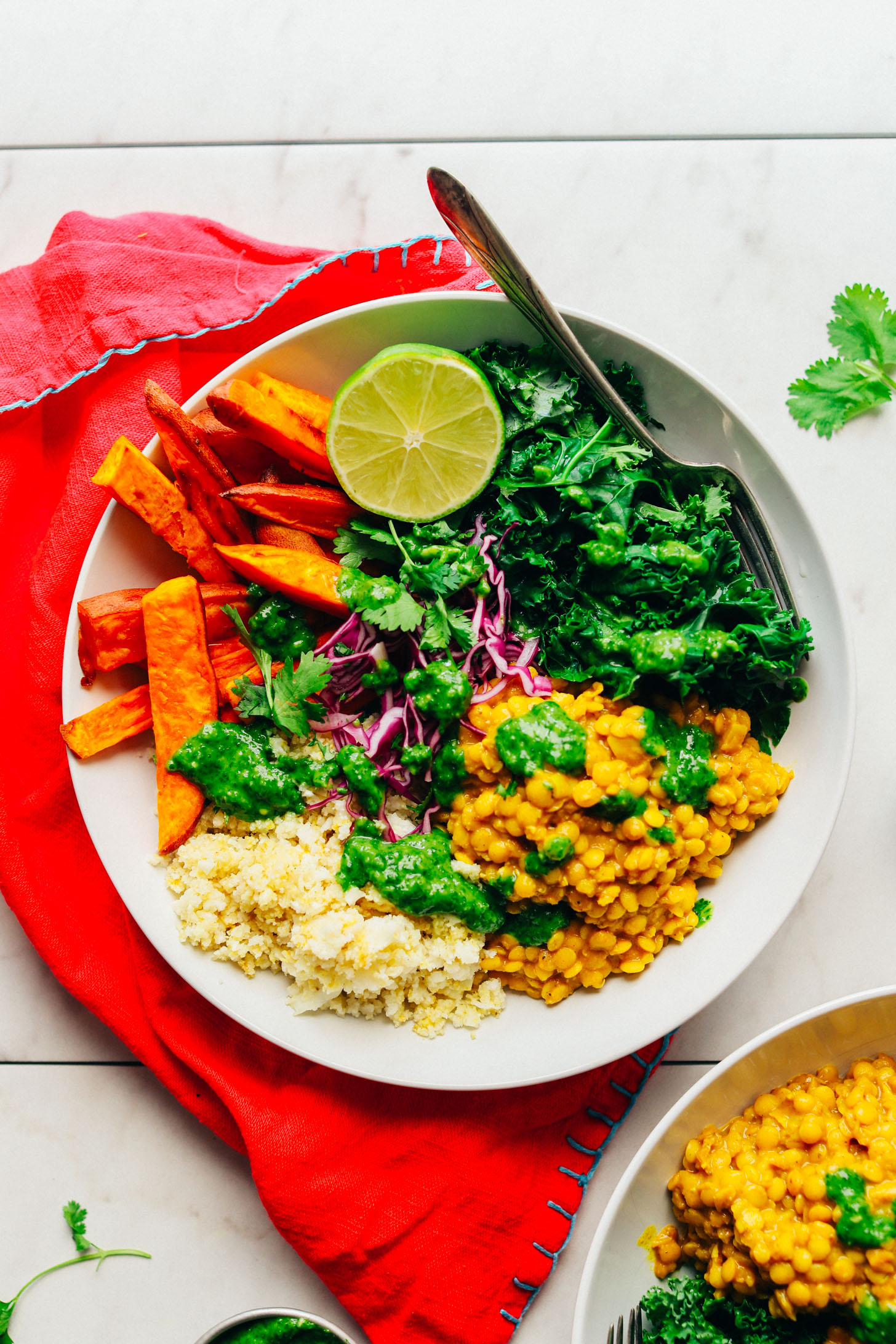 Top down shot showing a Curried Lentil Sweet Potato Bowl with half of a lime for serving