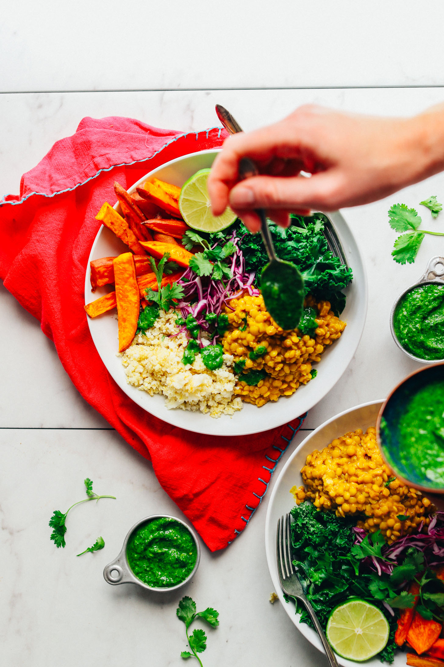 Drizzling cilantro chutney over a Curried Lentil Sweet Potato Bowl for a nourishing plant-based meal