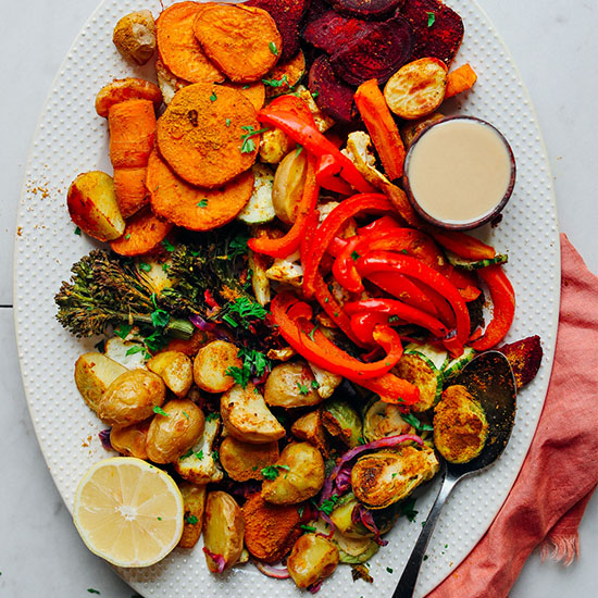 Platter of Oil-Free Roasted Vegetables with a bowl of tahini and a lemon half