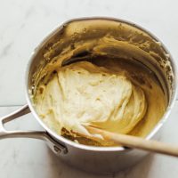 Wooden spoon in a pot of our Vegan Mozzarella Cheese