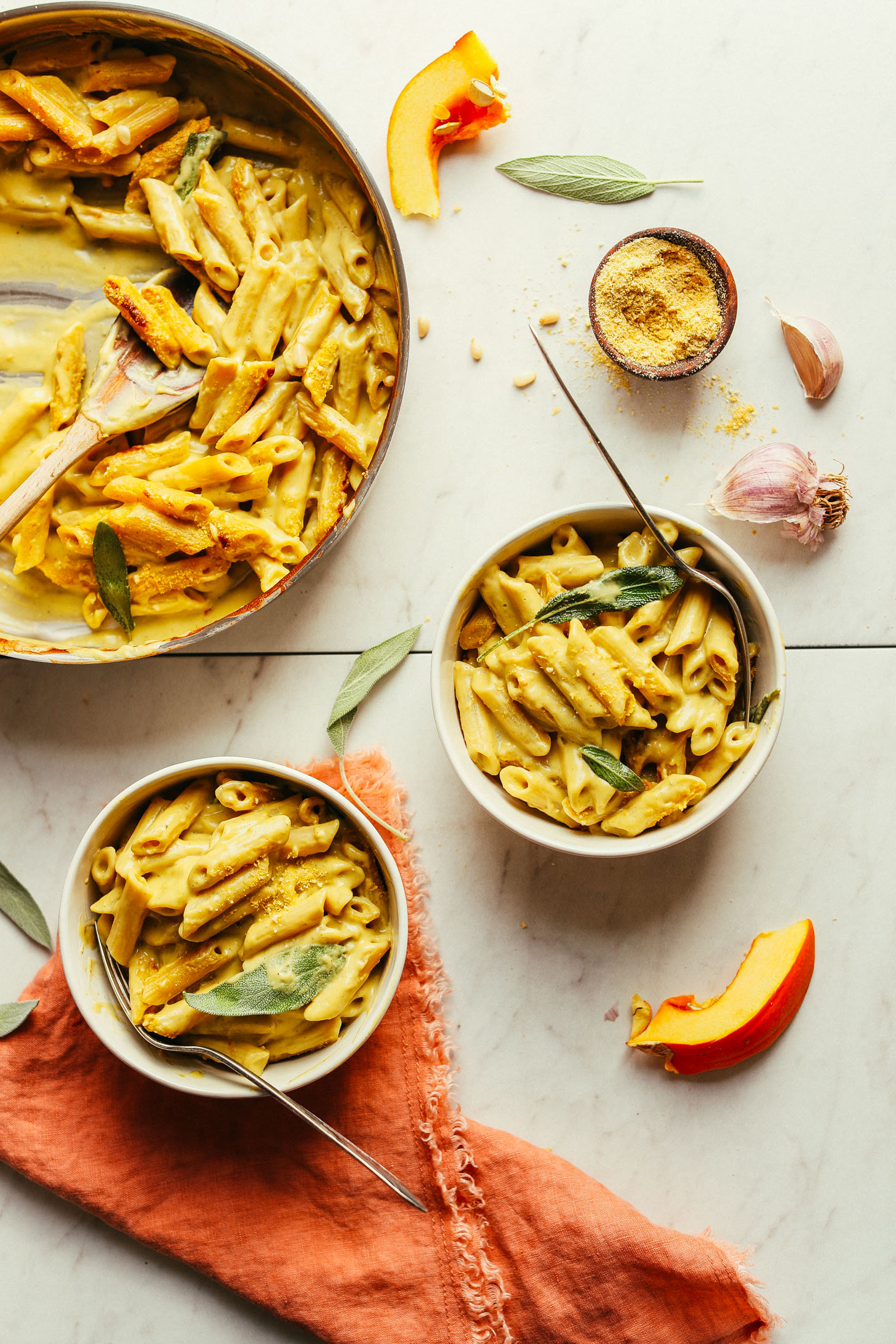 Serving two bowls of Pumpkin Mac 'n' Cheese from a large saute pan