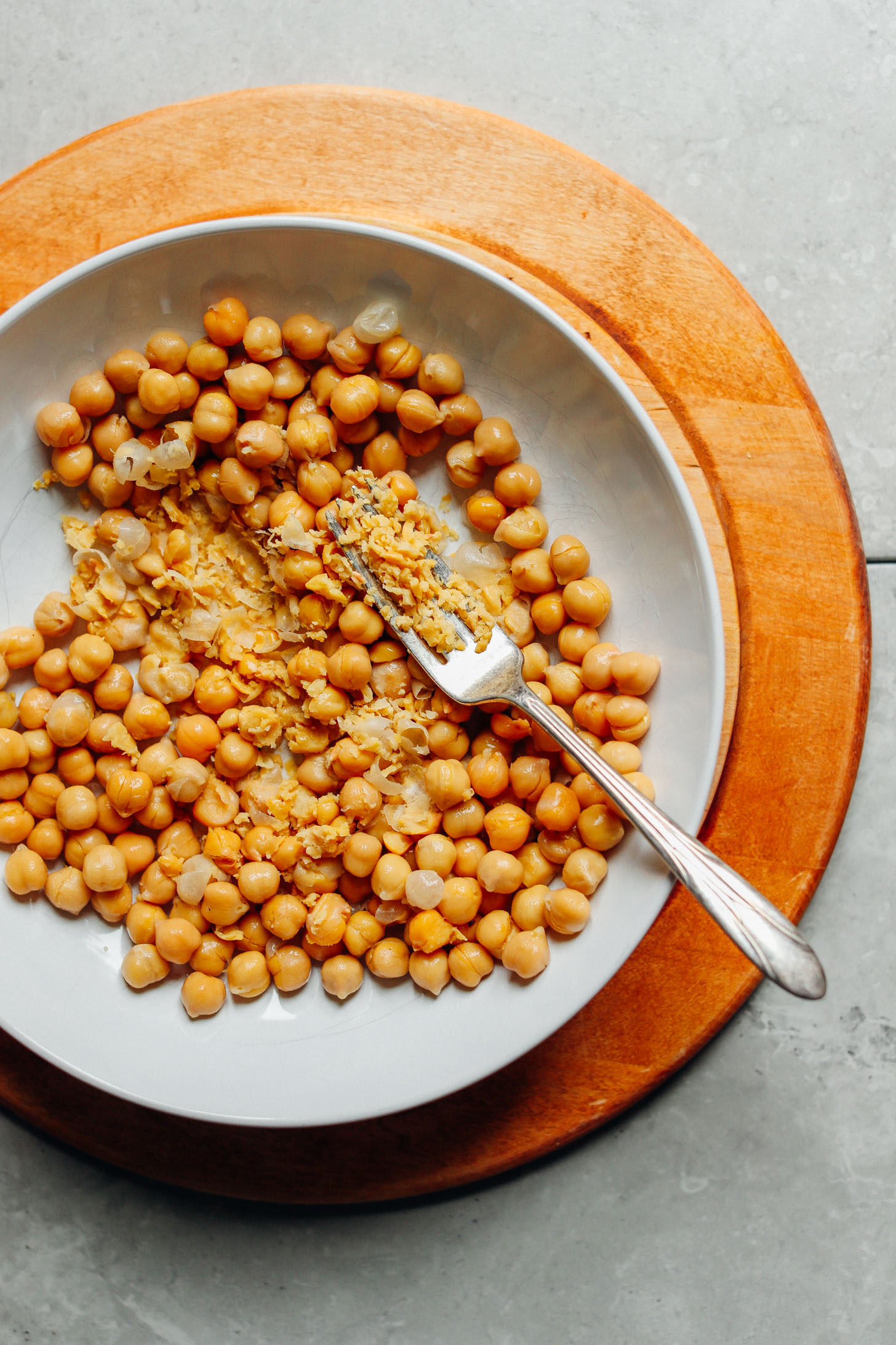 A plate of fiber- and protein-packed chickpeas showing some gently smashed by a fork