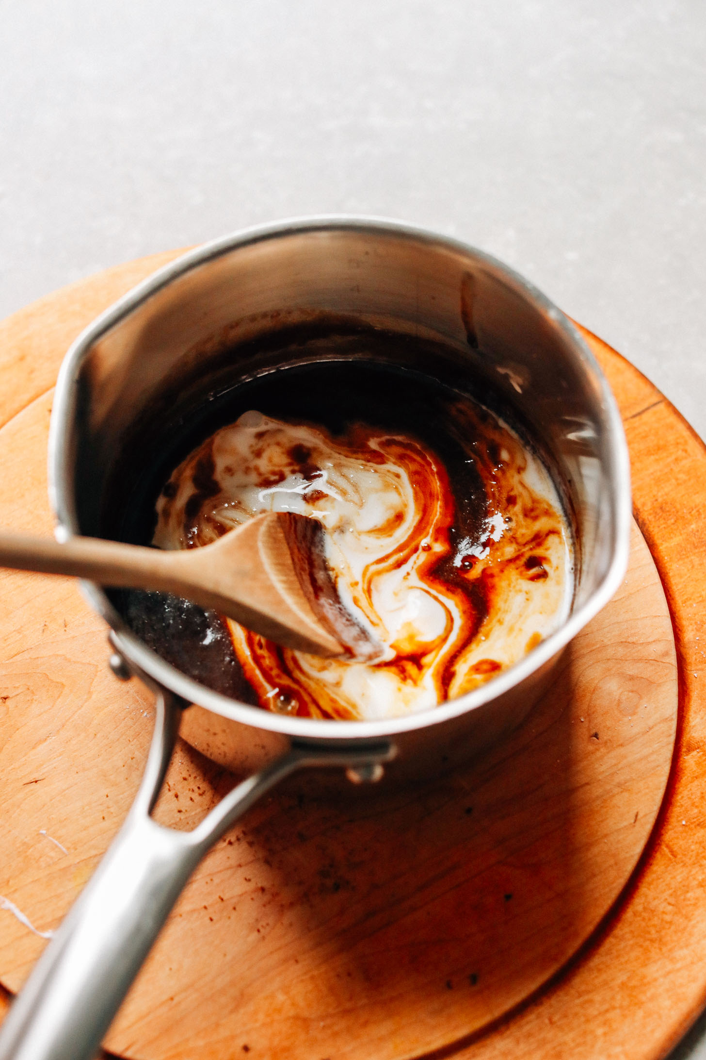 Stirring a saucepan of rich and creamy Vegan Caramel Sauce