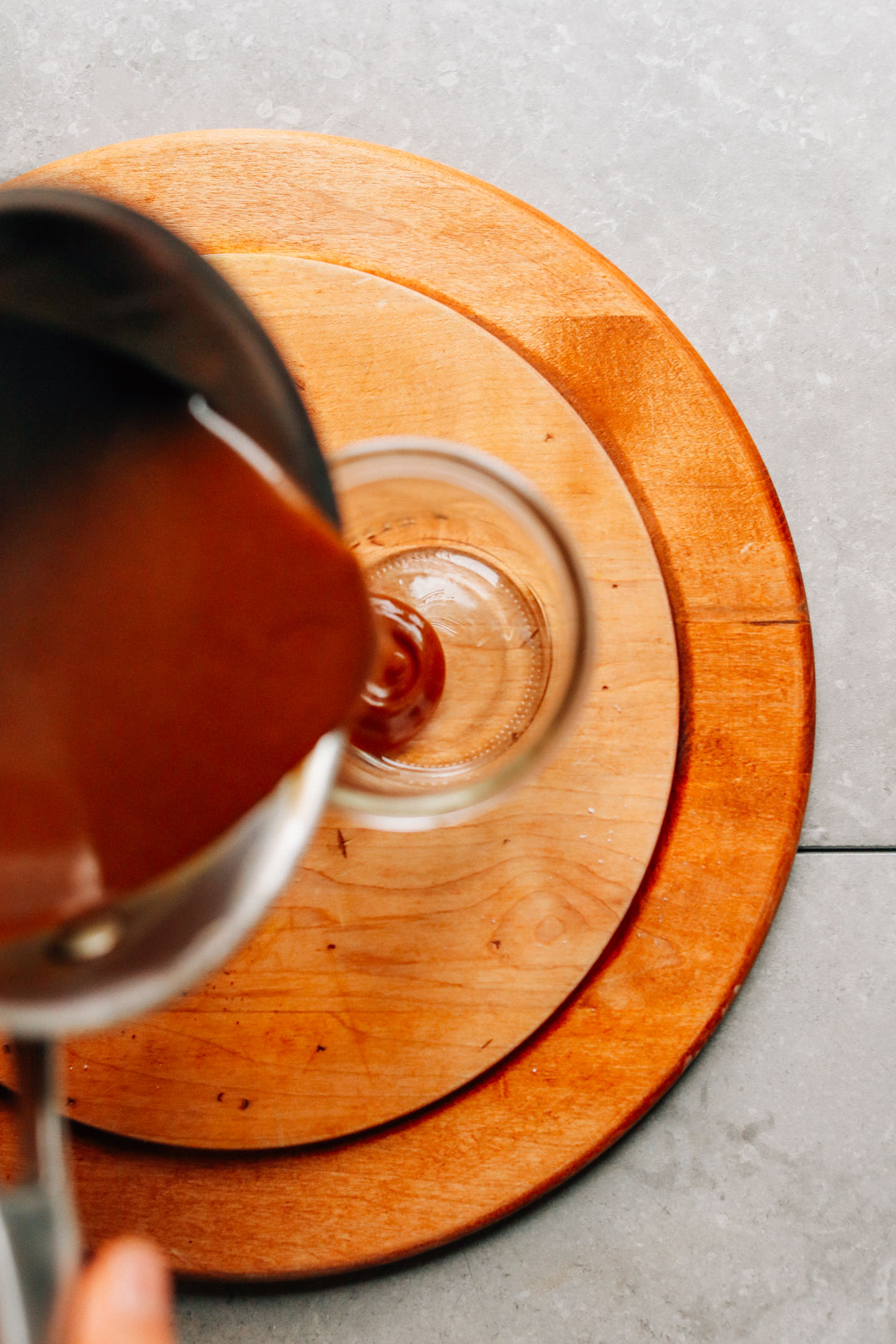 Pouring Vegan Caramel Sauce from saucepan to jar