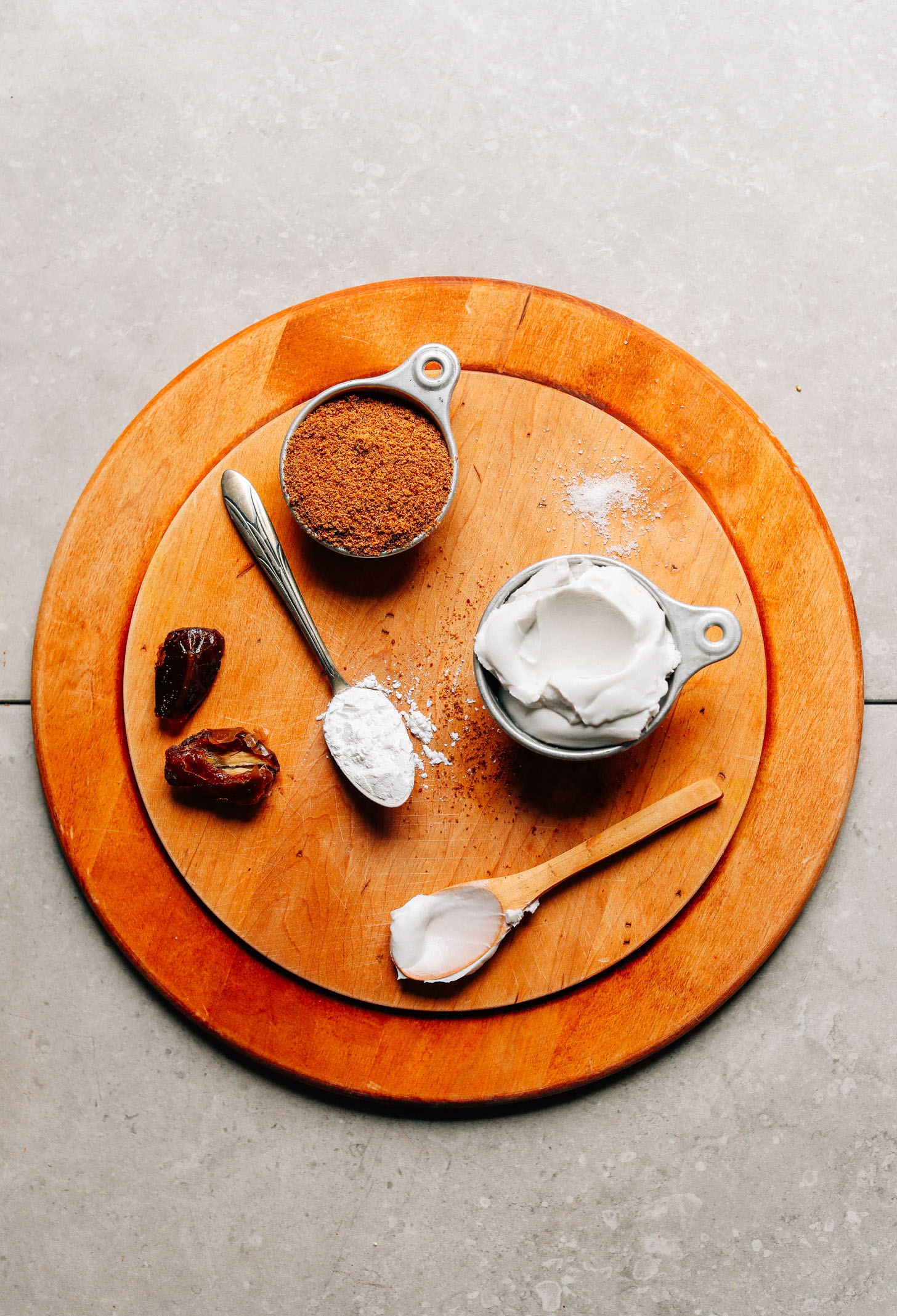 Wood cutting board with arrowroot starch, dates, coconut sugar, coconut cream, and salt for making gluten-free Vegan Caramel Sauce