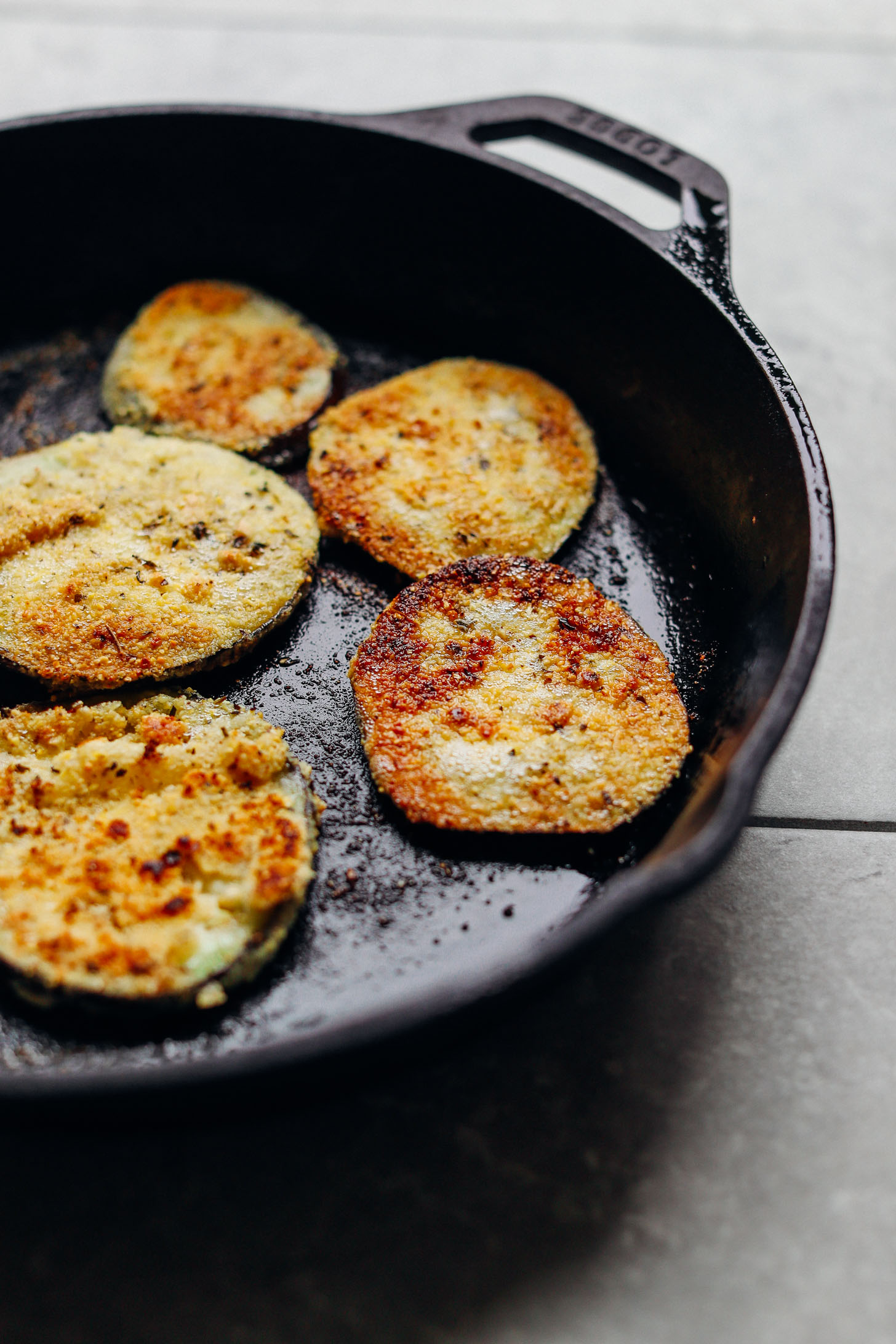 Sauteing Vegan Gluten-Free Crispy Eggplant Parmesan in a cast iron skillet