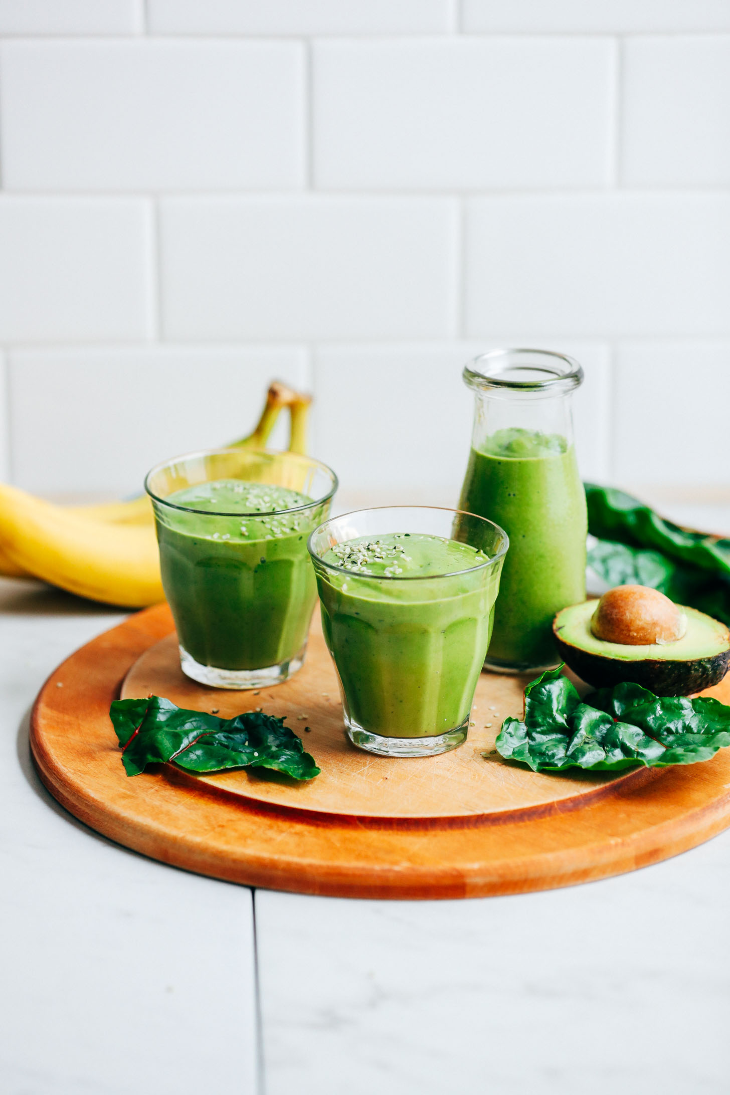 Two glasses and a pouring jug filled with our vibrant gluten-free and vegan Avocado Green Smoothie