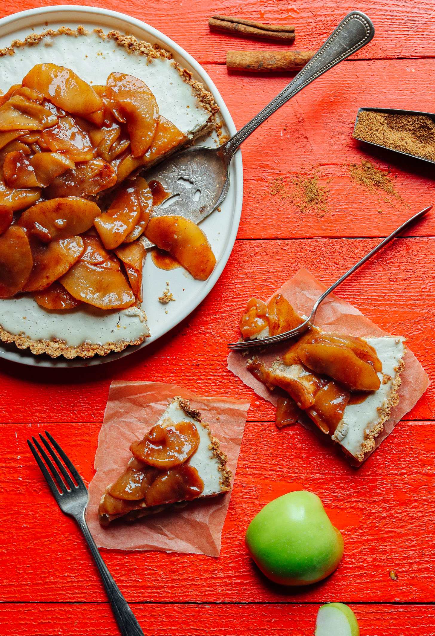 Slices of Caramel Apple Tart on parchment paper squares beside the whole dessert