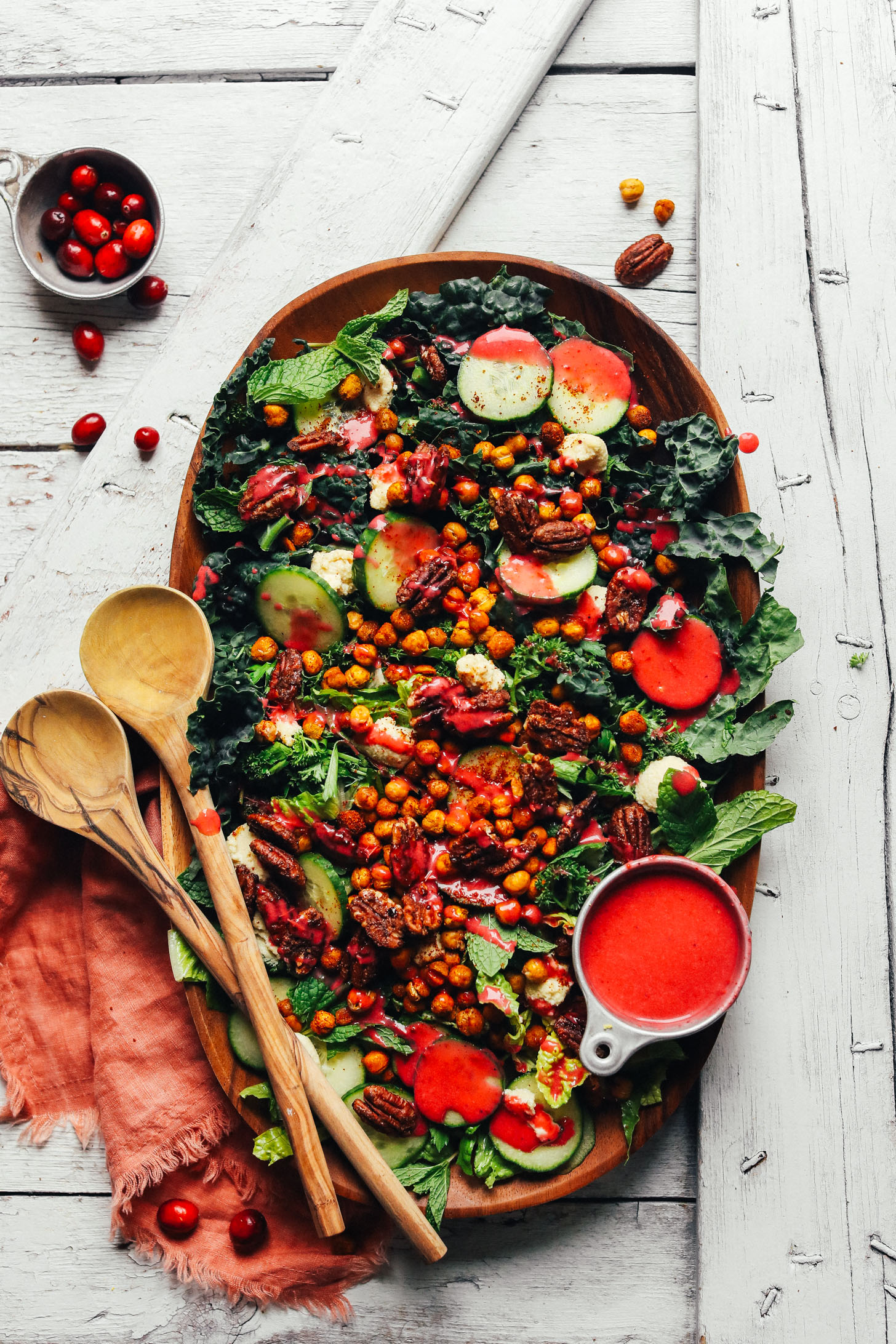 A large wooden serving platter filled with AMAZING Herbed Green Salad with Crispy Chickpeas and Cranberry Vinaigrette