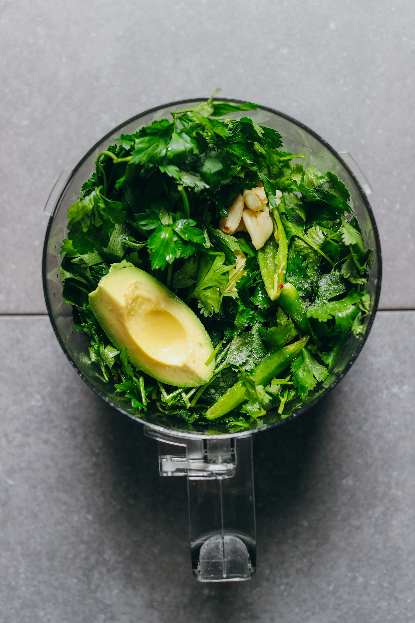 Food processor filled with ingredients for fresh Chimichurri