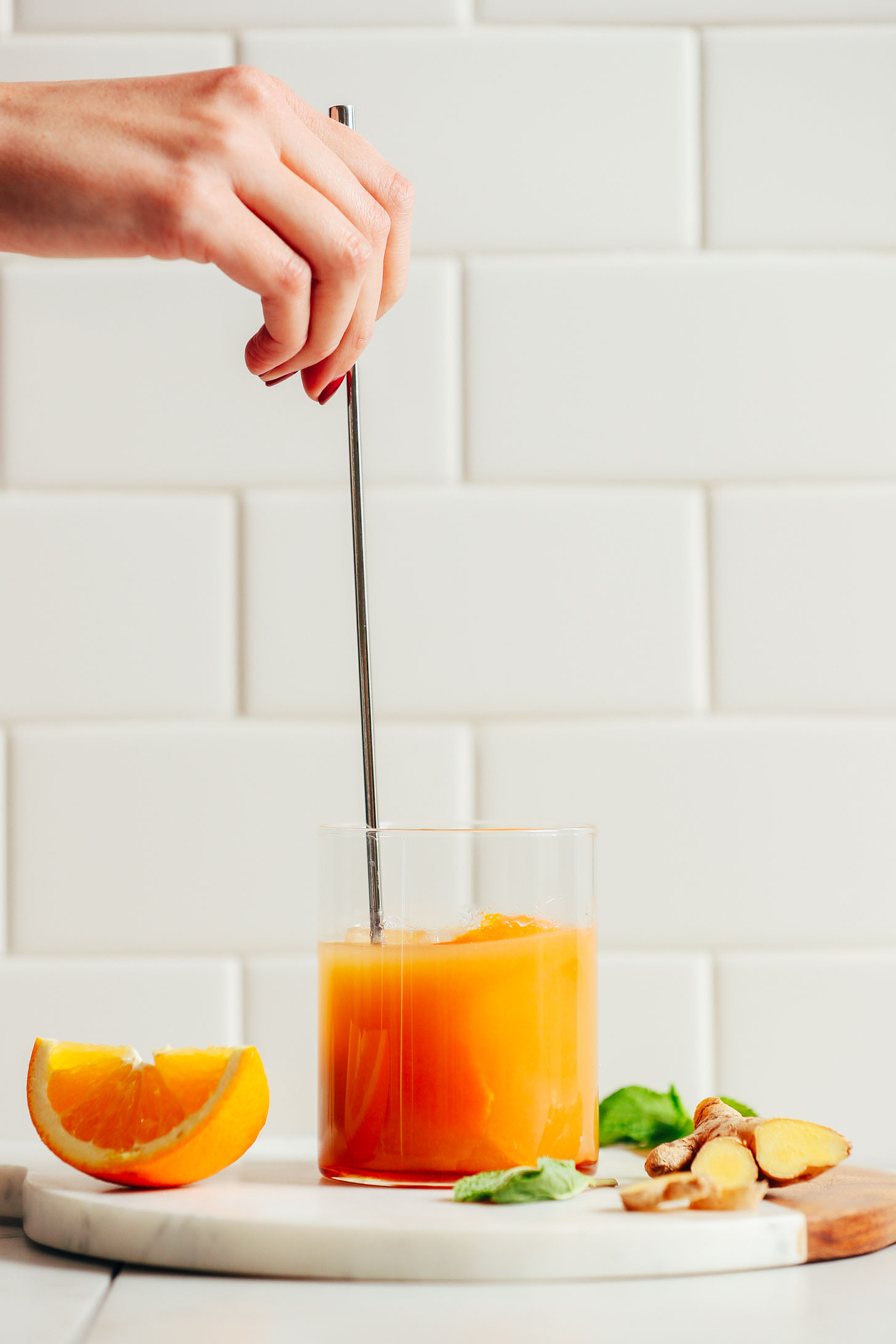 Using a bar spoon to stir our AMAZING Orange Whiskey Ginger with Mint for a perfect NYE cocktail
