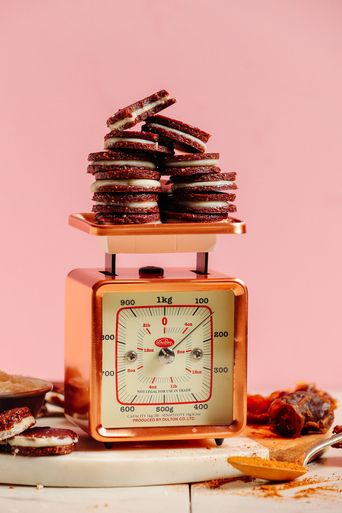 A vintage gold scale holding several gluten-free Raw Oreo Cookies