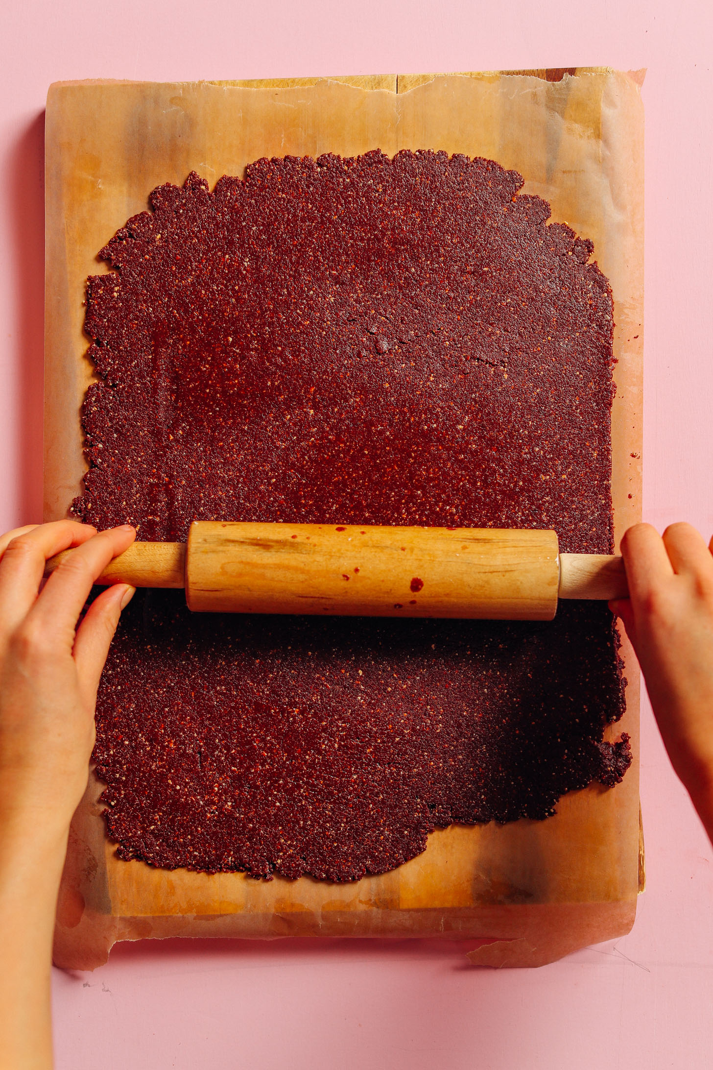 Using a rolling pin to roll out the dough for our amazing Raw Oreo Cookies