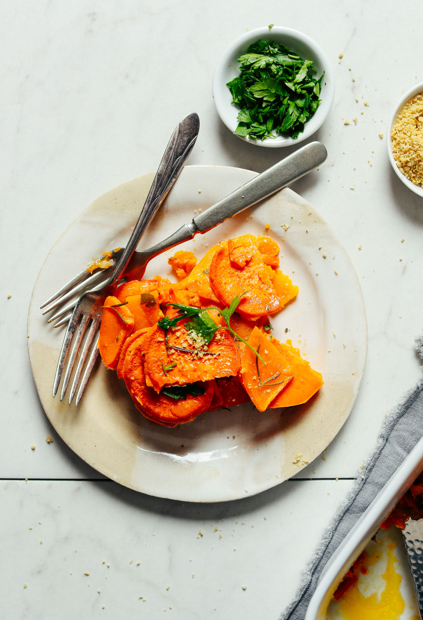 A tapas-size serving of Vegan Sweet Potato Butternut Squash Tortilla on a small plate with two forks