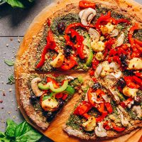 Cutting board with a pizza made using our Vegan Cauliflower Pizza Crust recipe