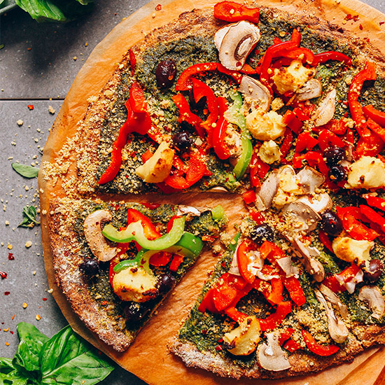 Cutting board with a pizza made using our Vegan Cauliflower Pizza Crust recipe