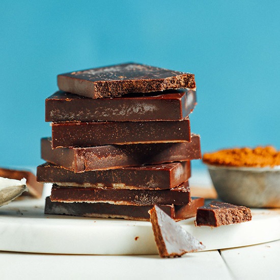 Stack of Coconut Carob Bars on a marble and wood cutting board