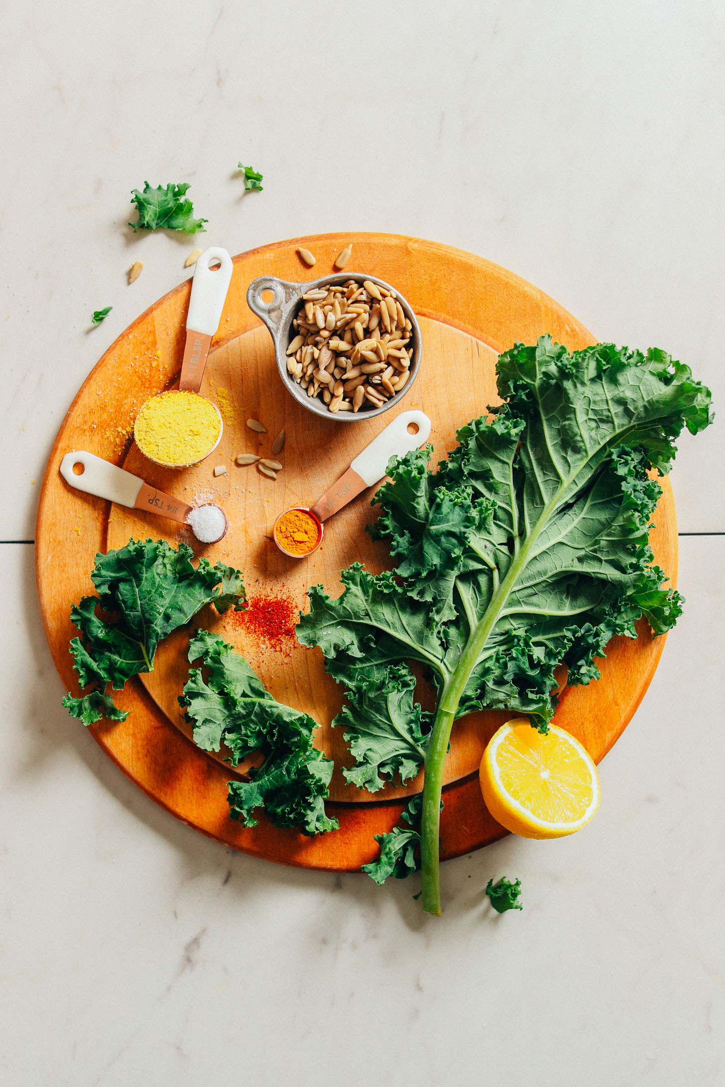Kale, sunflower seeds, lemon, nutritional yeast, and spices for making oil-free Crispy Baked Kale Chips with Sunflower Seed Cheeze