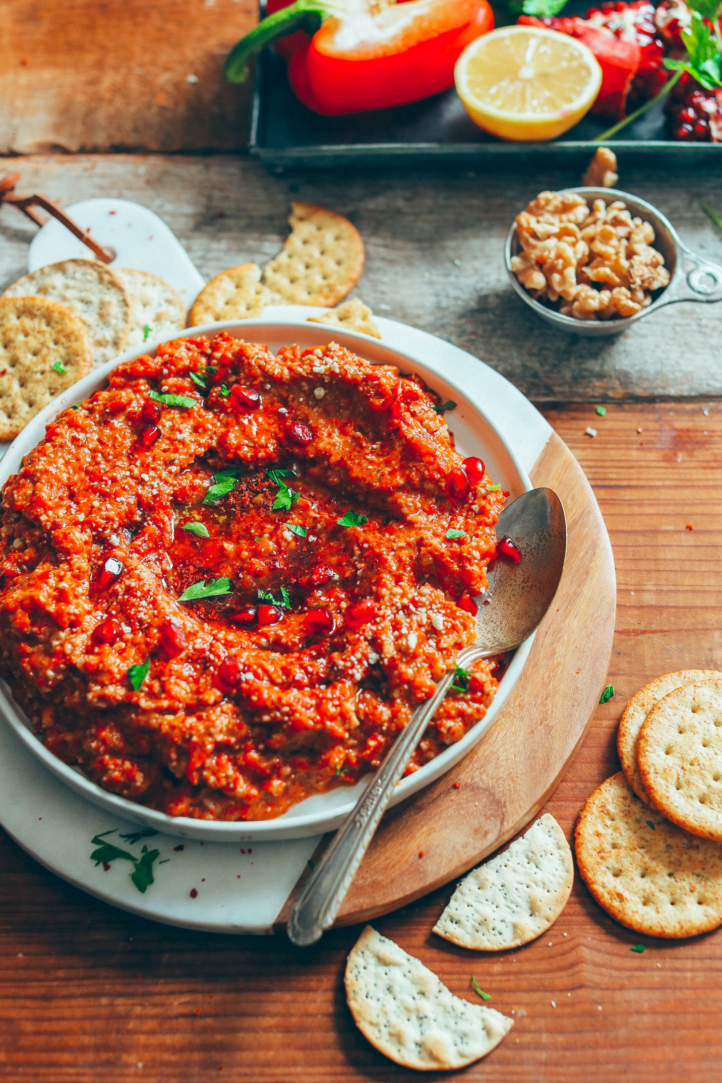 A big bowl of gluten-free Muhamarra Dip served alongside gluten-free crackers