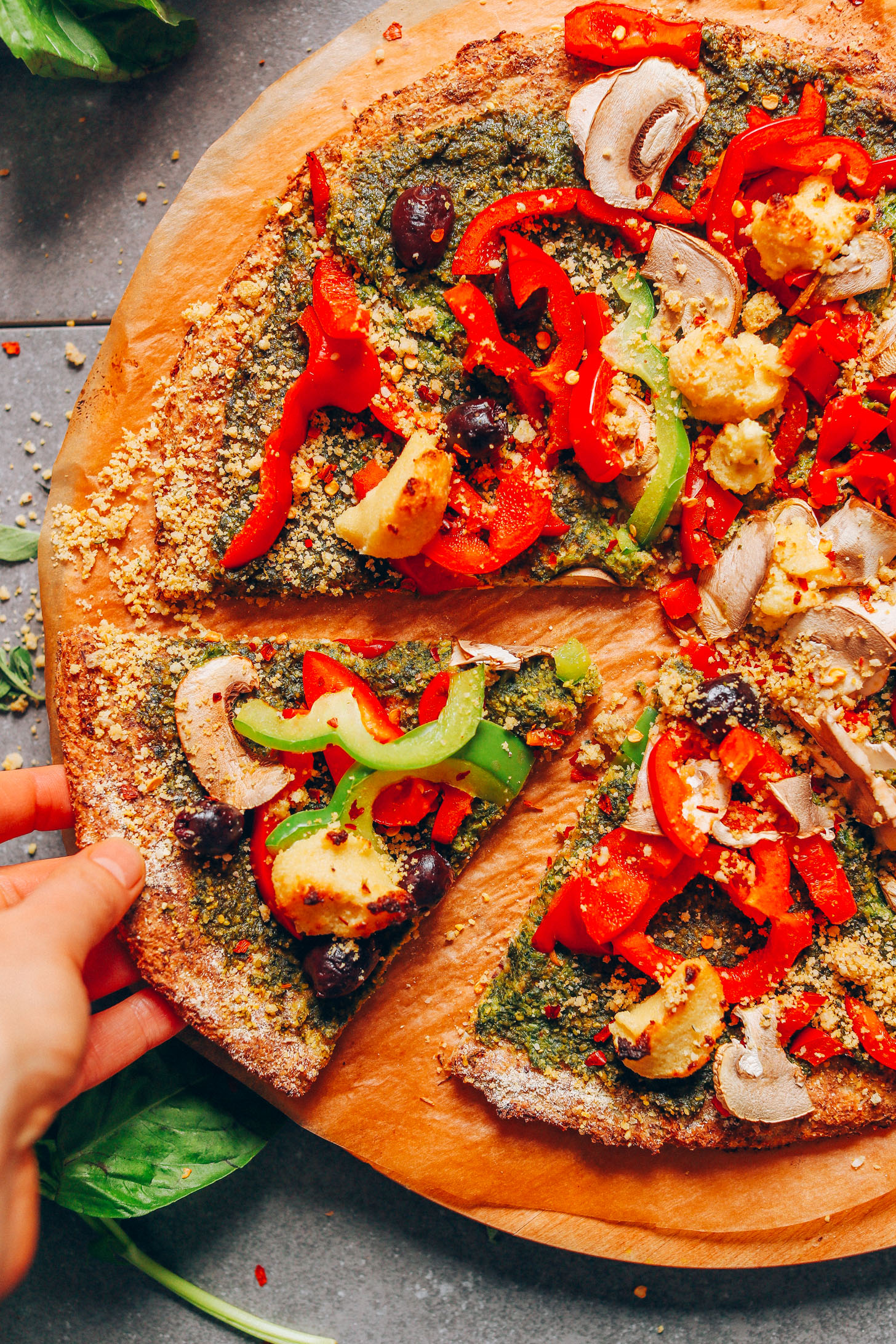Picking up a slice of vegan pizza made with cauliflower crust