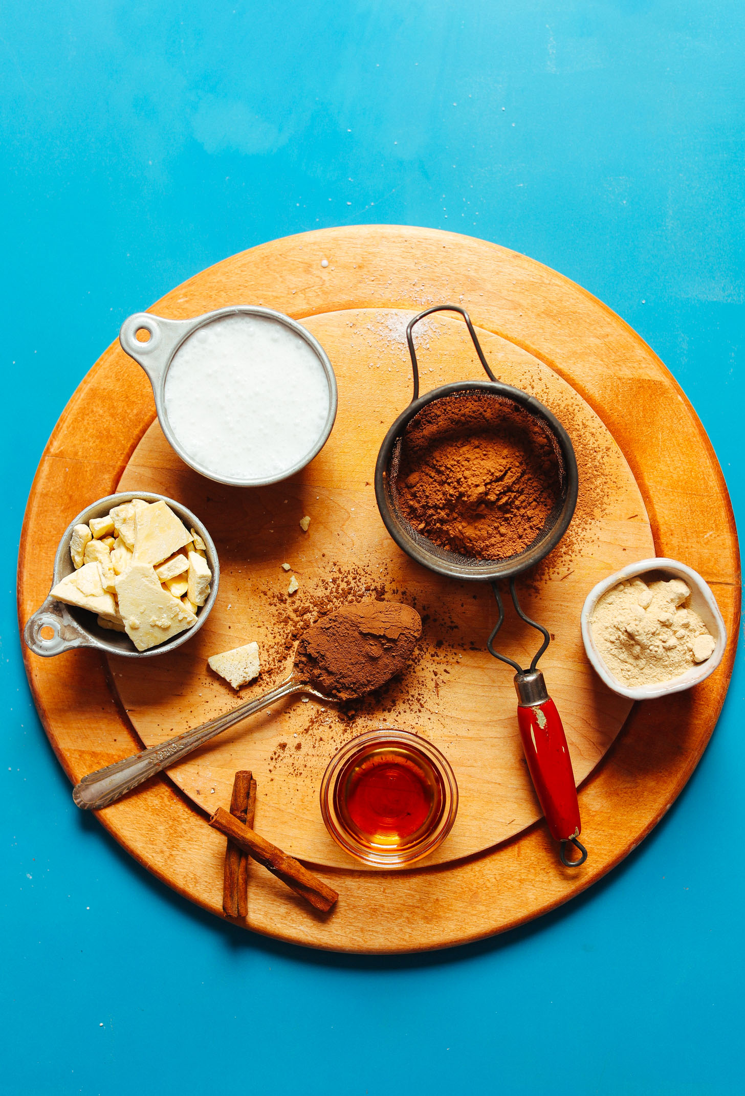 Cinnamon sticks, maple syrup, cacao butter, coconut milk, carob powder, cocoa powder, and maca for making our Feel Good Vegan Hot Chocolate