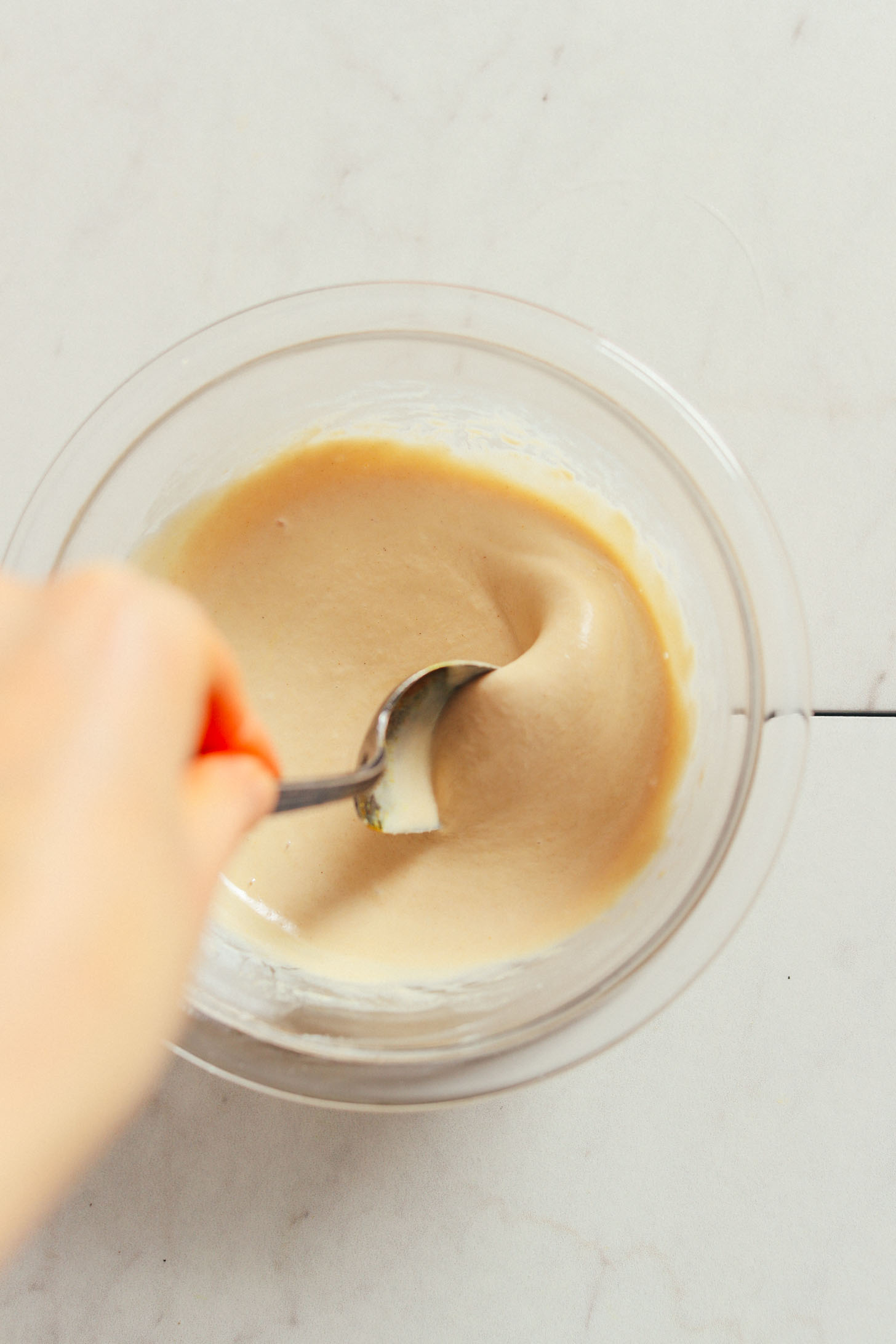 Stirring tahini dressing for our plant-based Loaded Kale Salad