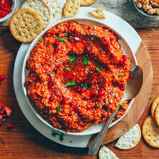Big bowl of Gluten-Free Muhamarra Dip beside crackers for dipping