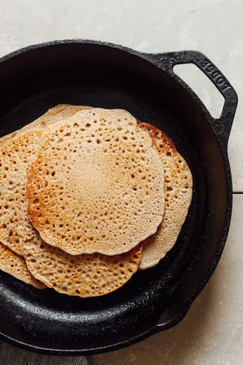 An overhead shot of buckwheat vegan crepes in a cast iron skillet