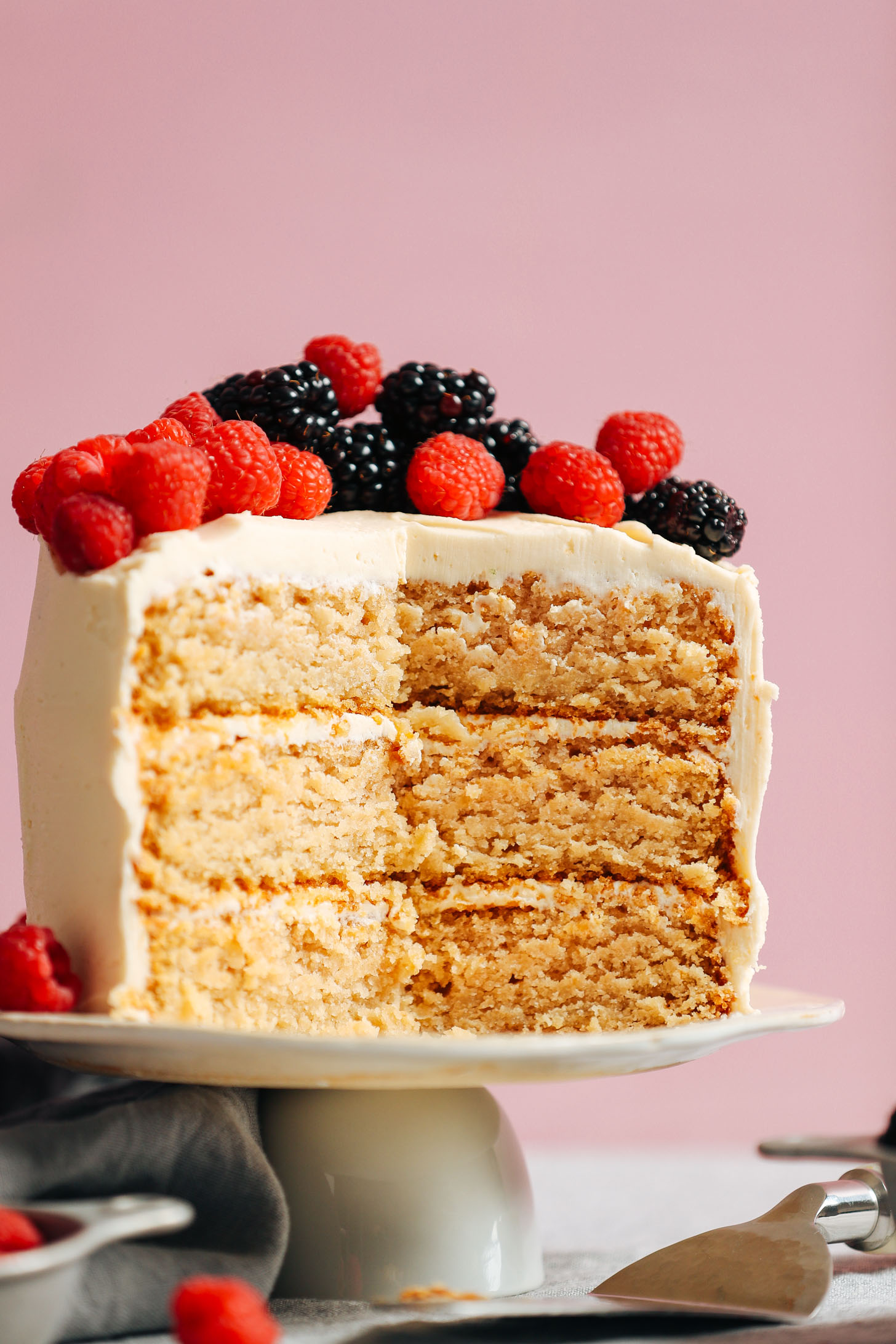 1-Bowl Vegan Gluten-Free Vanilla Cake displayed on a serving platter and topped with fresh raspberries and blackberries
