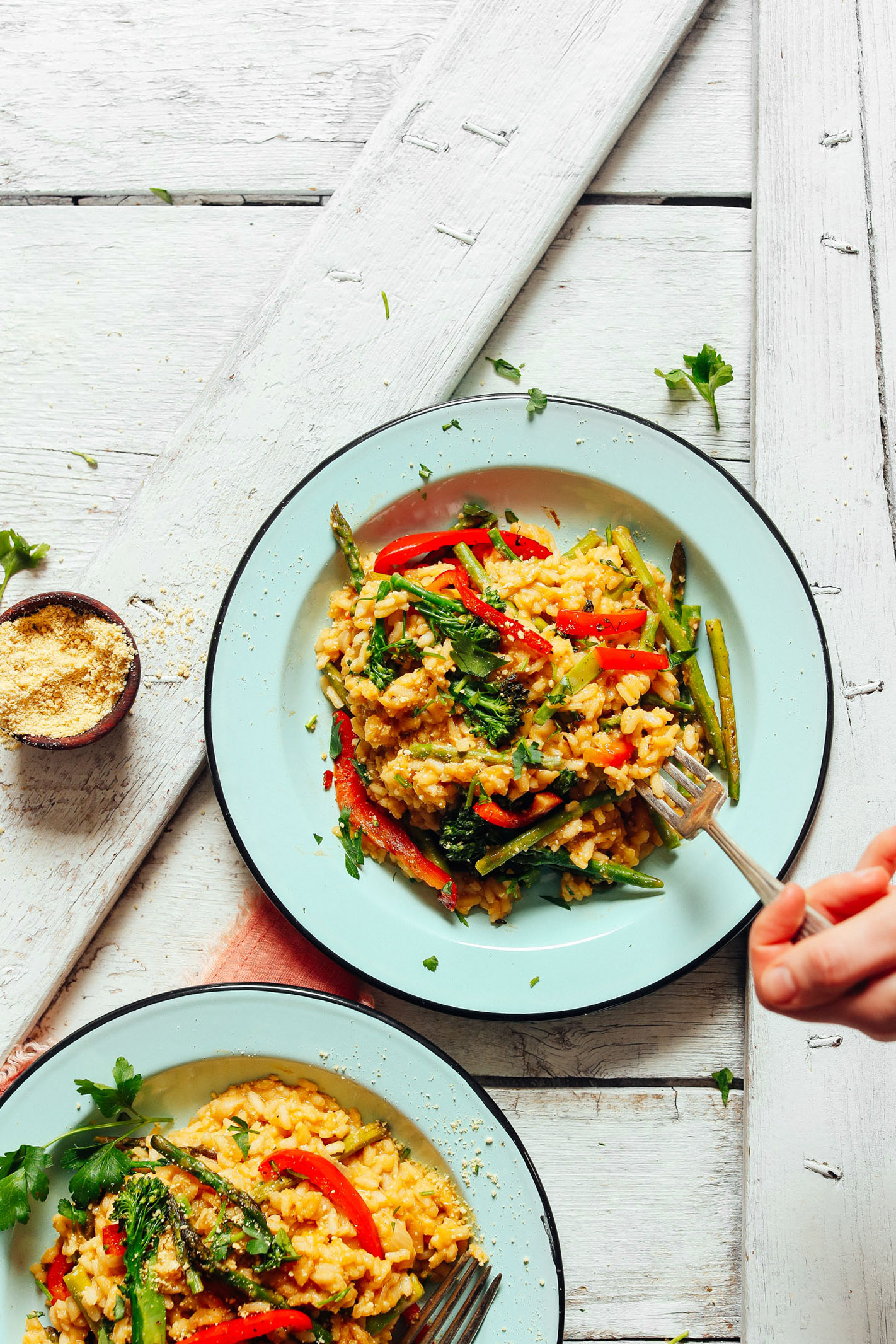 Two serving bowls filled with Creamy Vegetable Risotto for an easy plant-based dinner