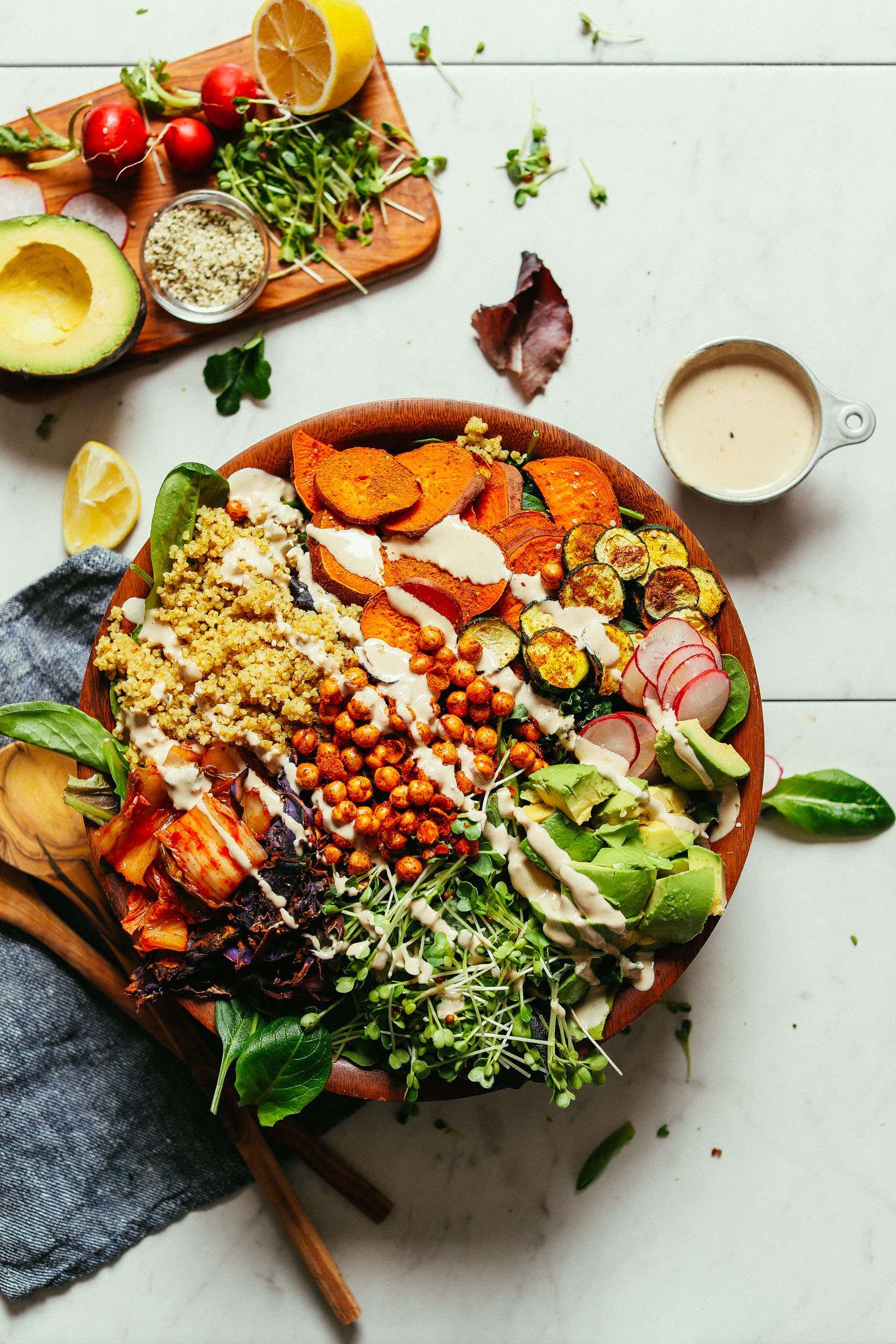 A large salad bowl filled with our Abundance Green Salad with Savory Tahini Dressing- the perfect gluten-free vegan meal
