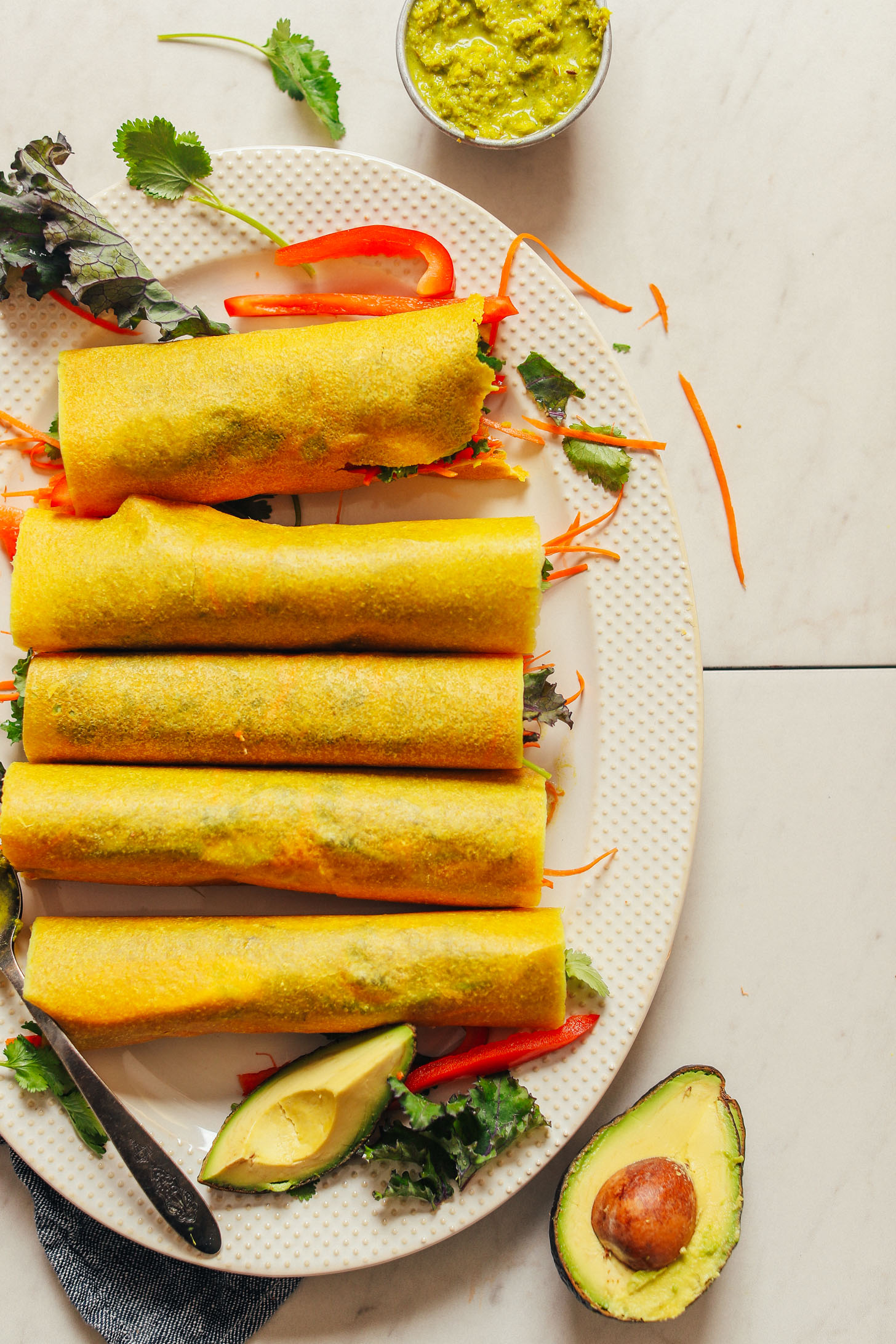 Platter of gluten-free and vegan coconut wraps filled with hummus, veggies, and curry paste