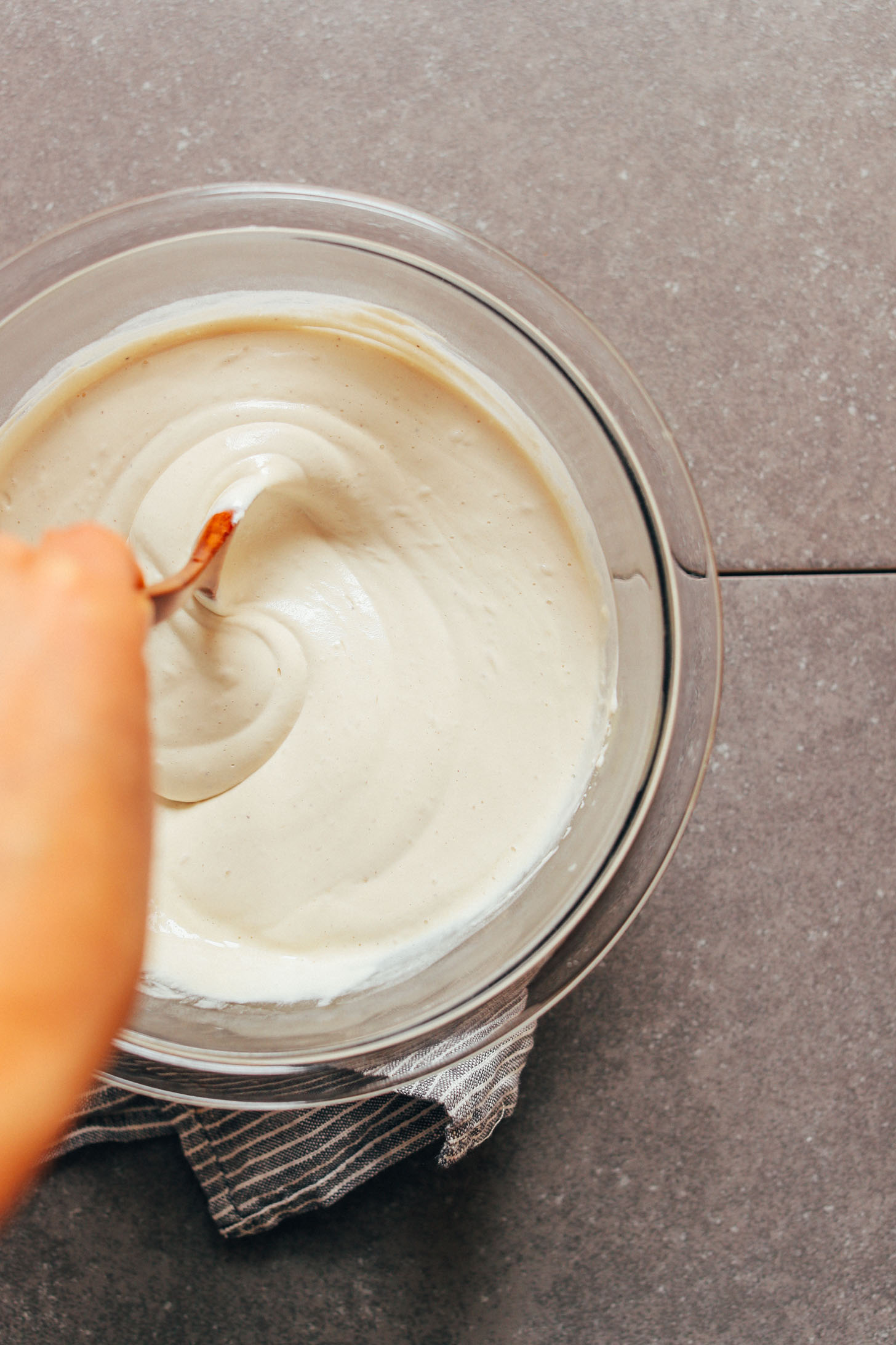 Giving a bowl of our vegan sour cream recipe a stir