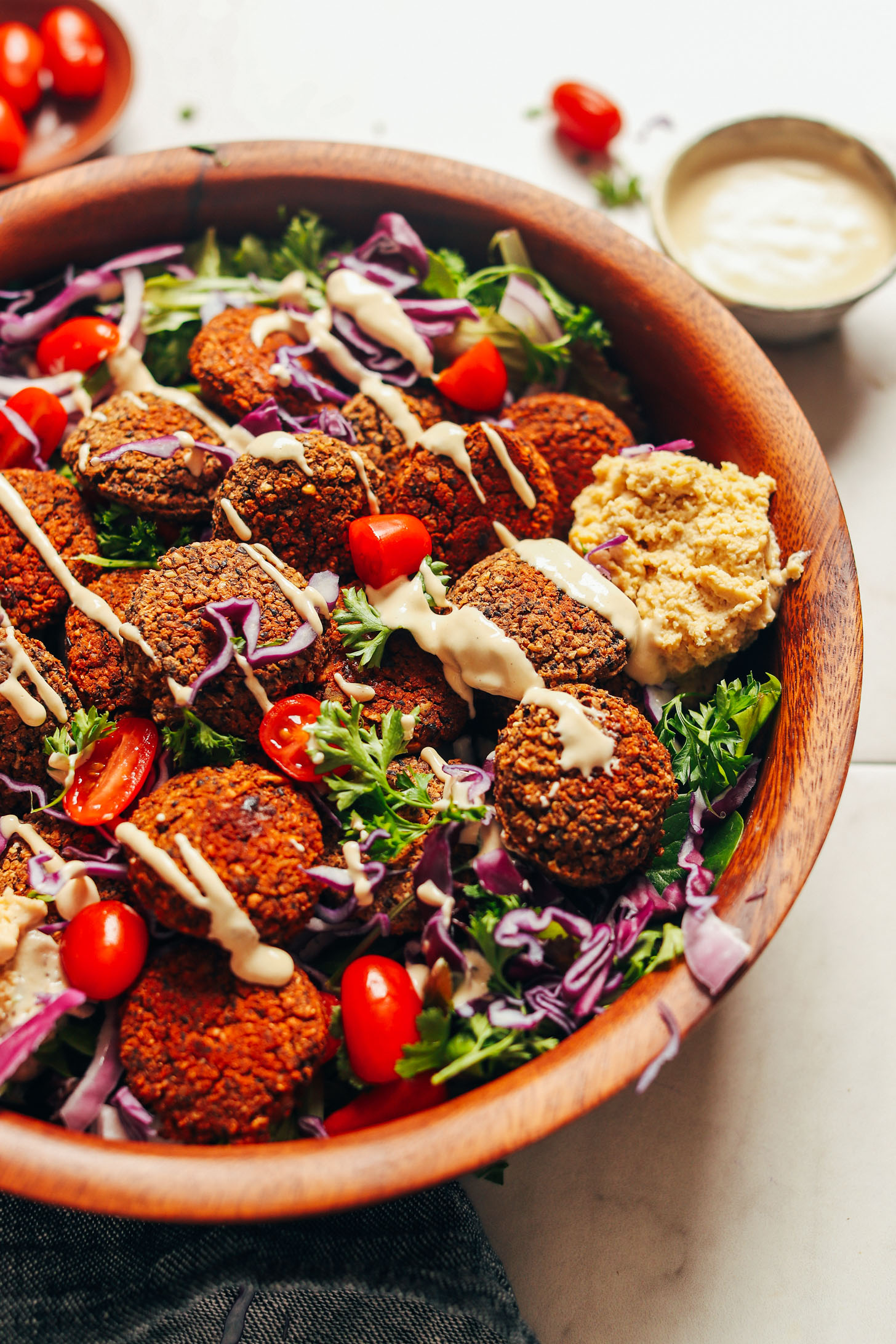 Serving bowl filled with greens and vegetables and topped with Black Bean Quinoa Falafel to make a hearty plant-based meal
