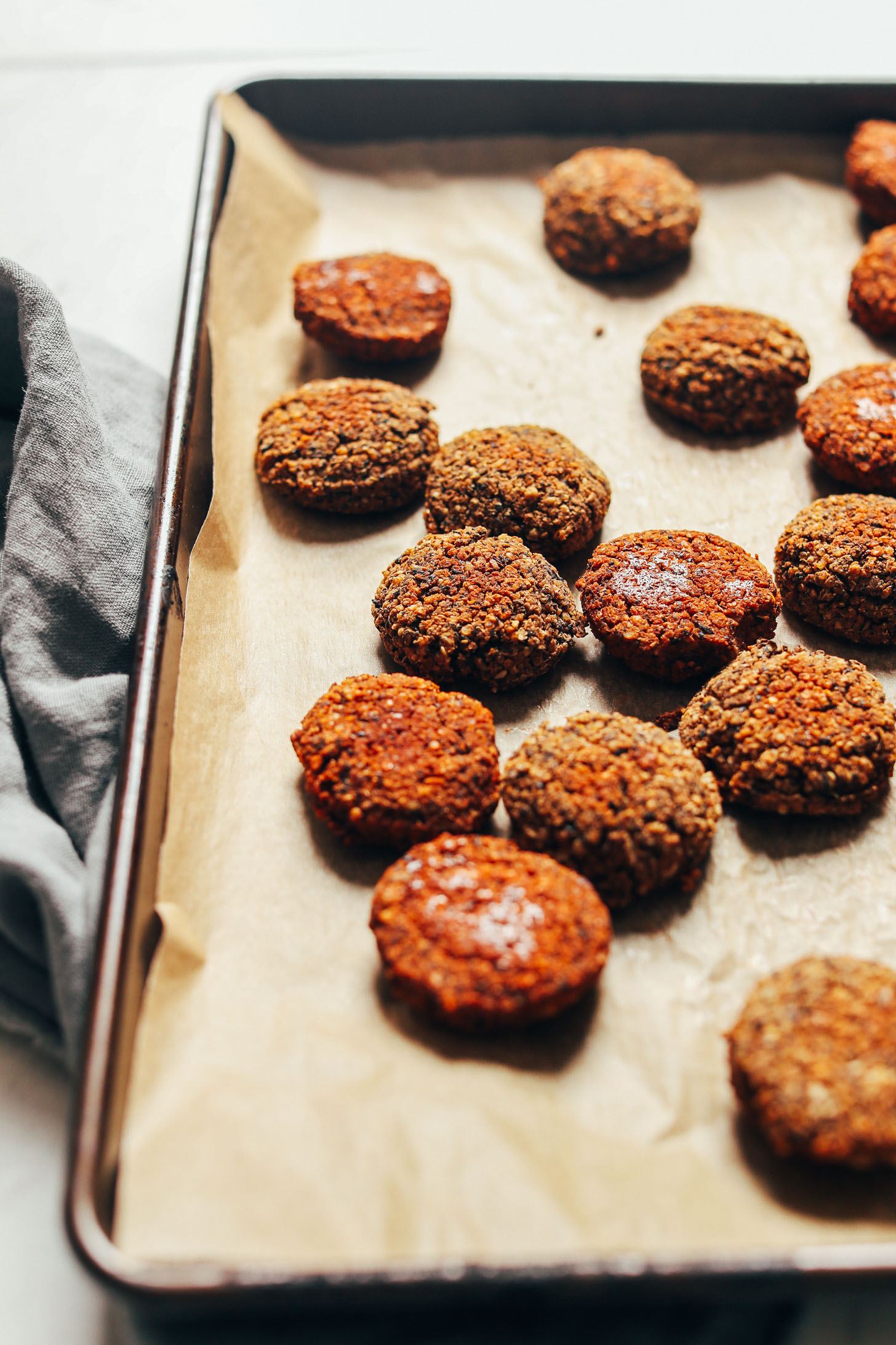 Perfectly baked Black Bean Quinoa Falafel on a parchment-lined baking sheet
