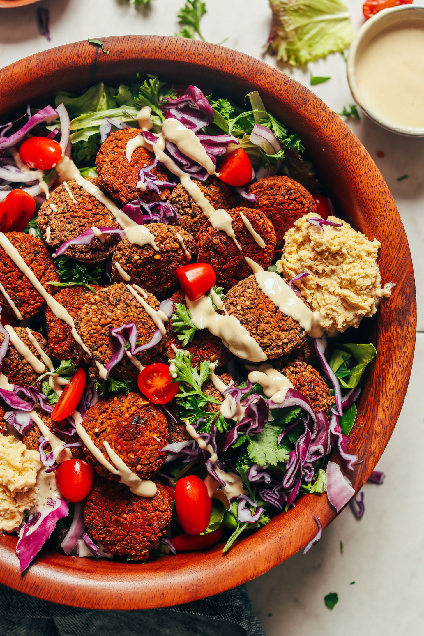 Serving bowl featuring our Black Bean Quinoa Falafel on a bed of mixed greens