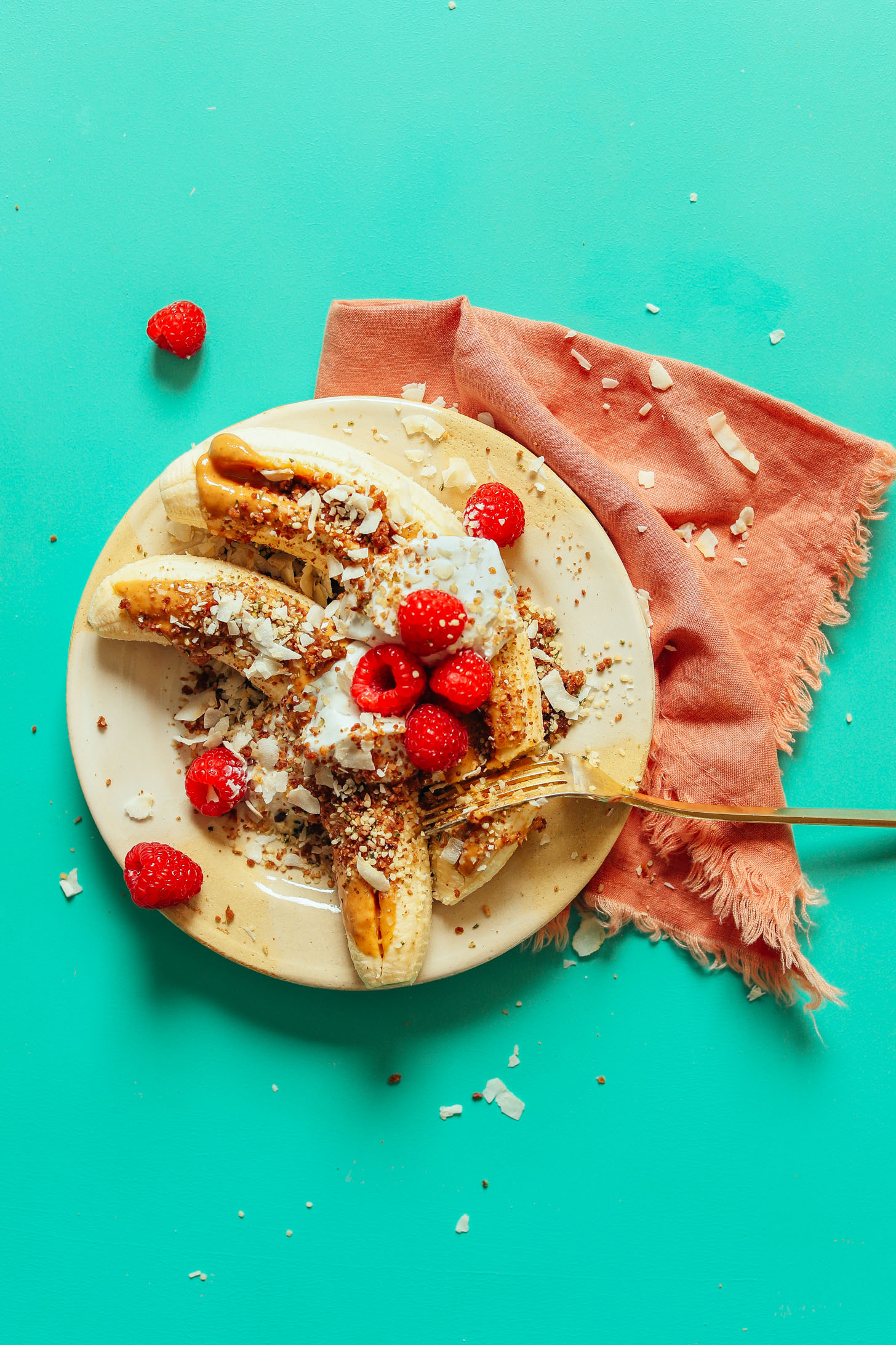 A serving plate with these protein and fiber-rich Raw Banana Splits served with Nut Butter, Coconut Yogurt, Berries, and more!