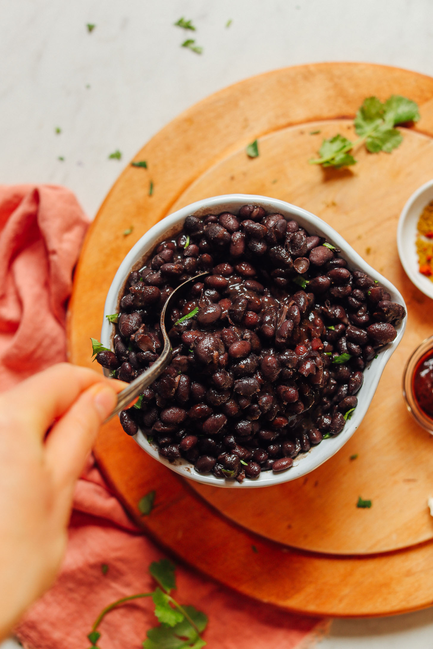 Grabbing a spoonful of homemade black beans that are perfectly tender and flavorful