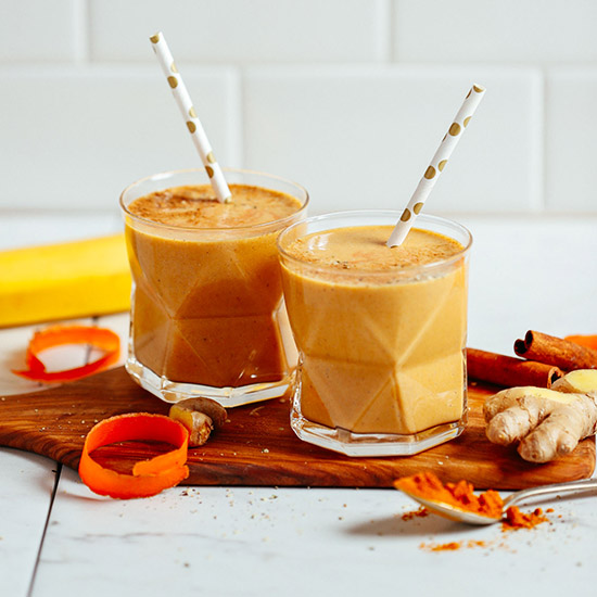 Our Vegan Golden Milk Smoothie served in two glasses with straws