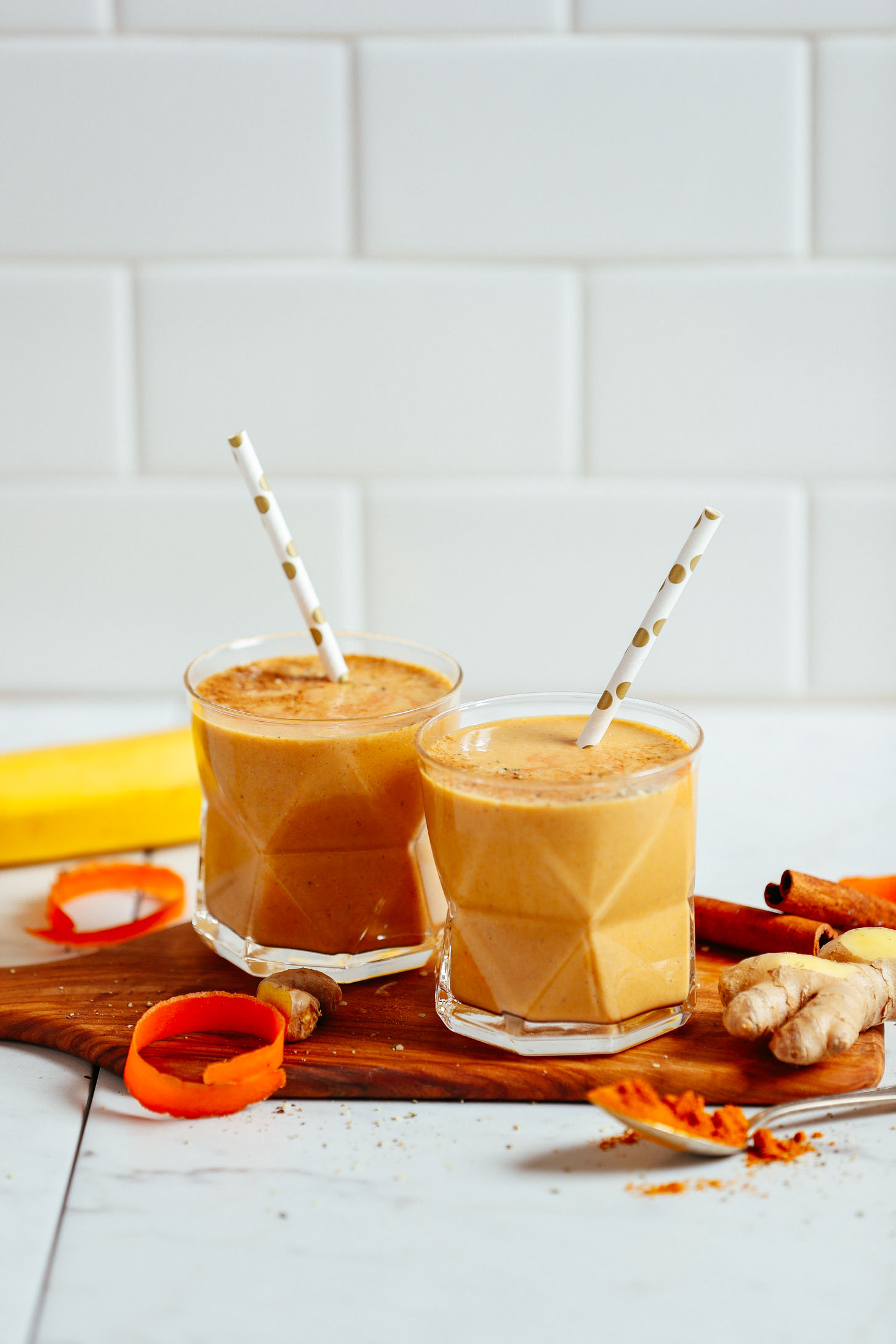 Our Vegan Golden Milk Smoothie served in two glasses with straws