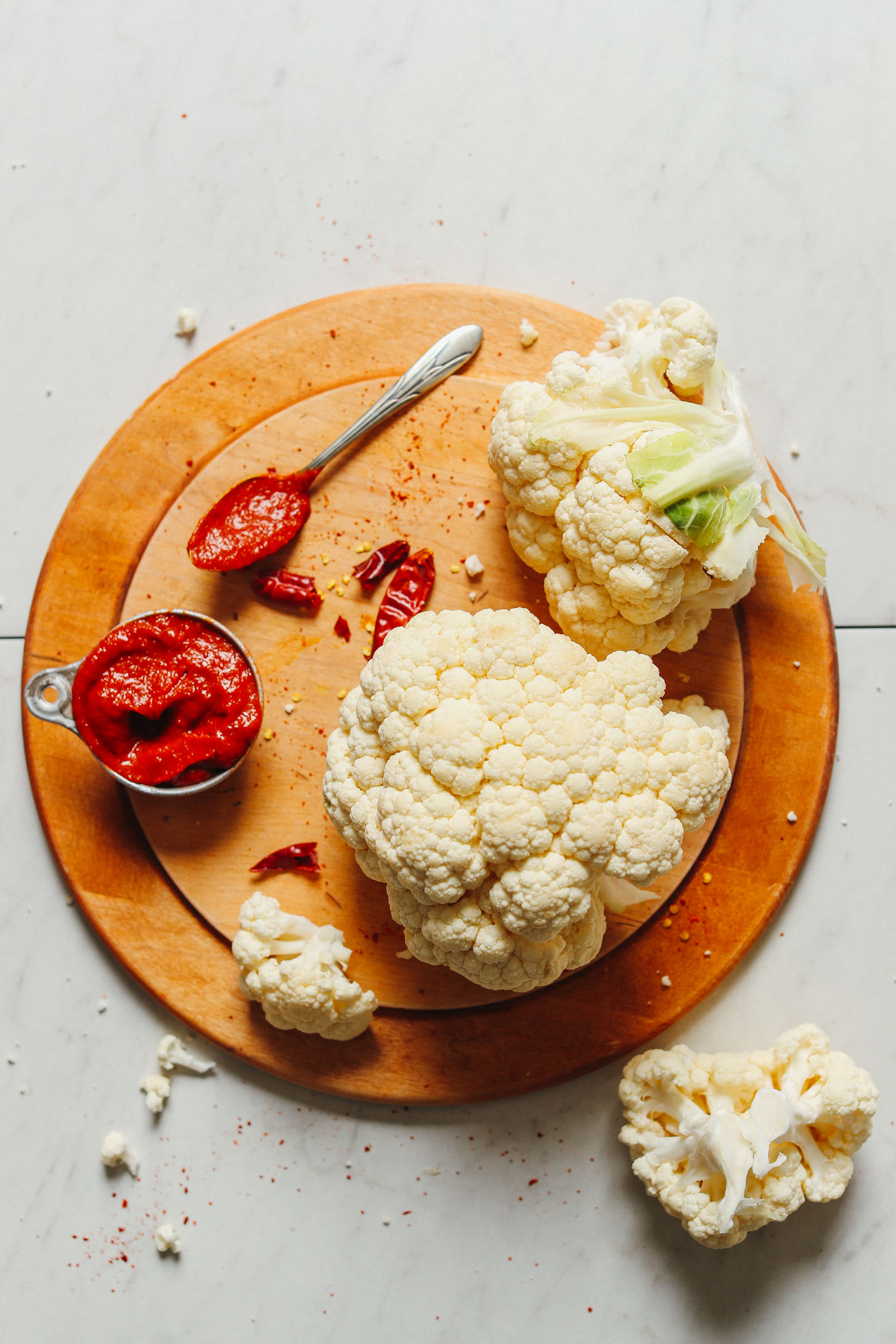 Wood cutting board with cauliflower and Korean Gochujang Sauce for making Korean-Spiced Cauliflower Wings