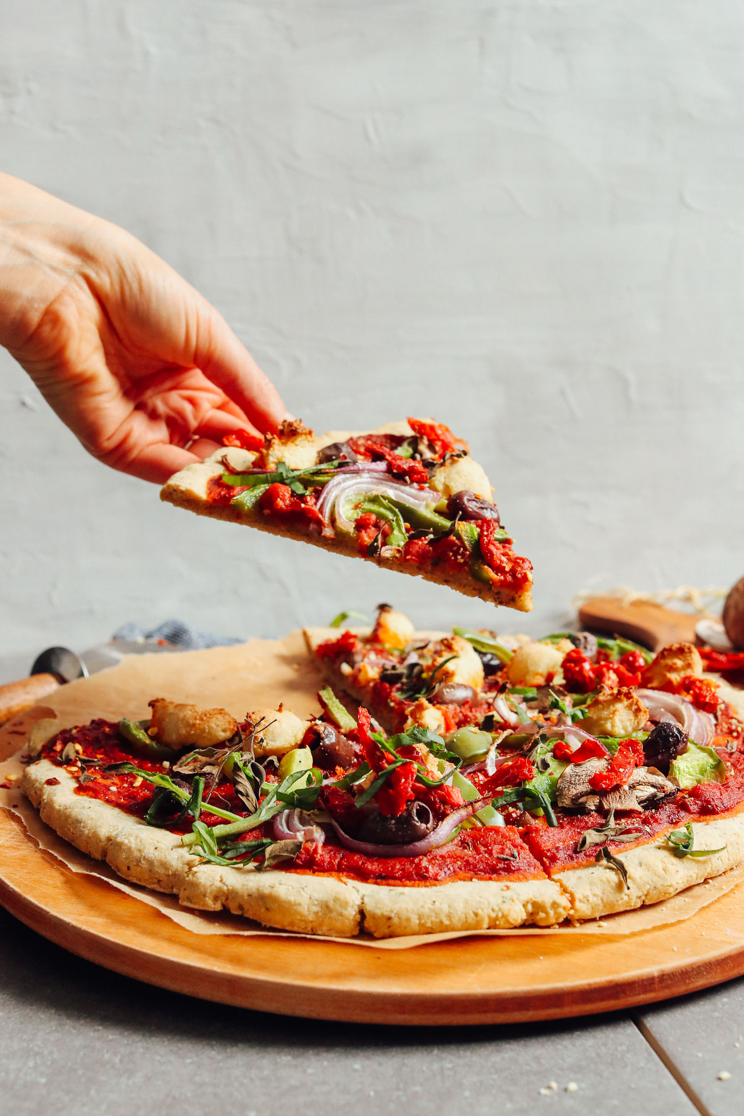 Grabbing a slice of pizza created using our Gluten-Free Pizza Crust recipe