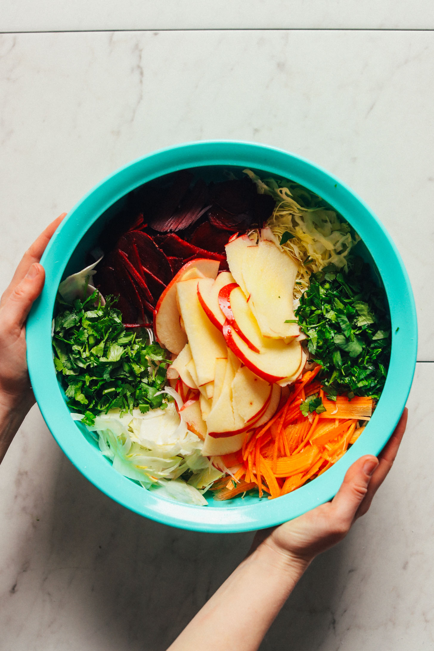 Large blue serving bowl showcasing the vegetables chosen for our favorite version of the customizable Super Cleansing Slaw
